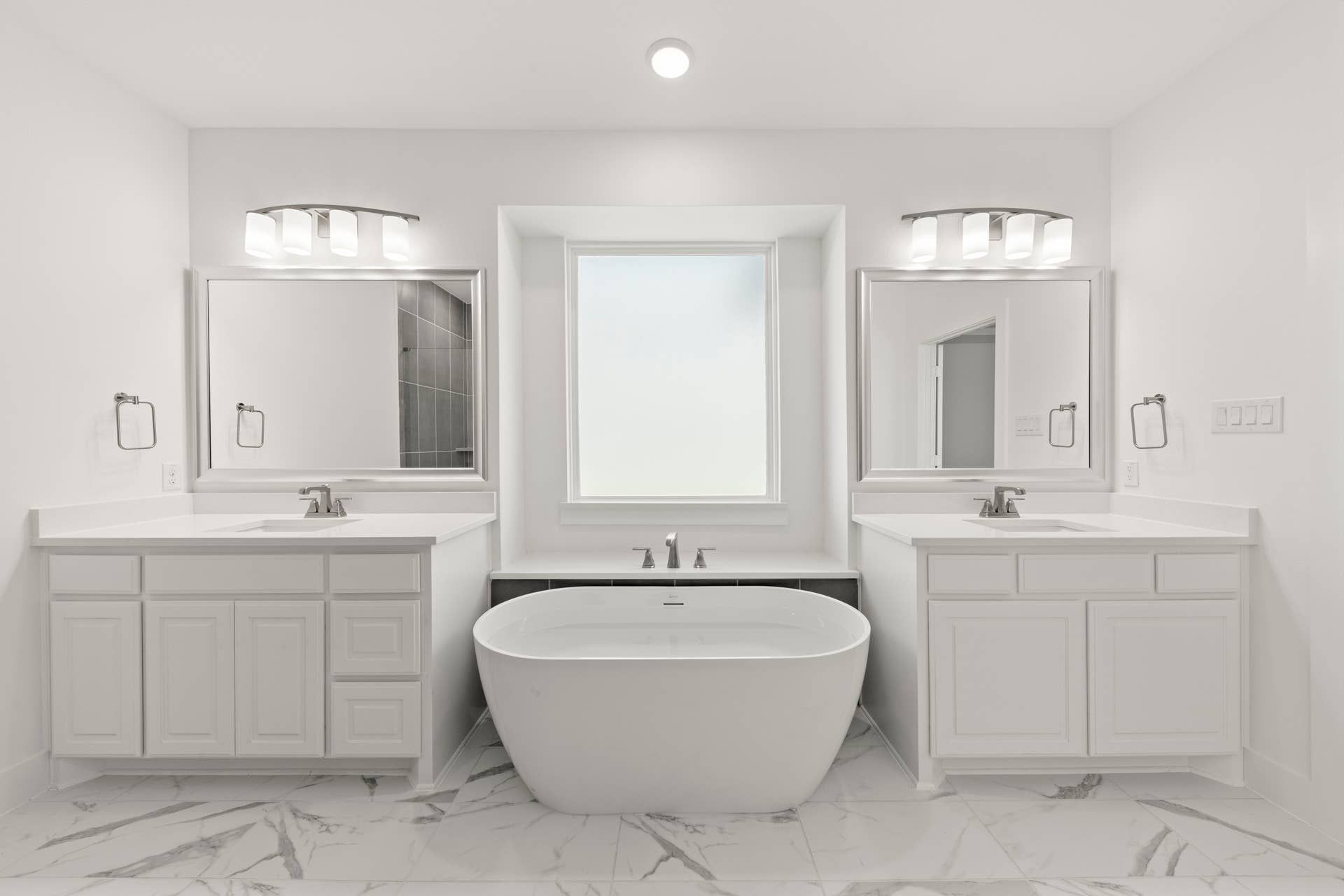 Luxury bathroom with freestanding tub, dual sinks, and elegant lighting fixtures.