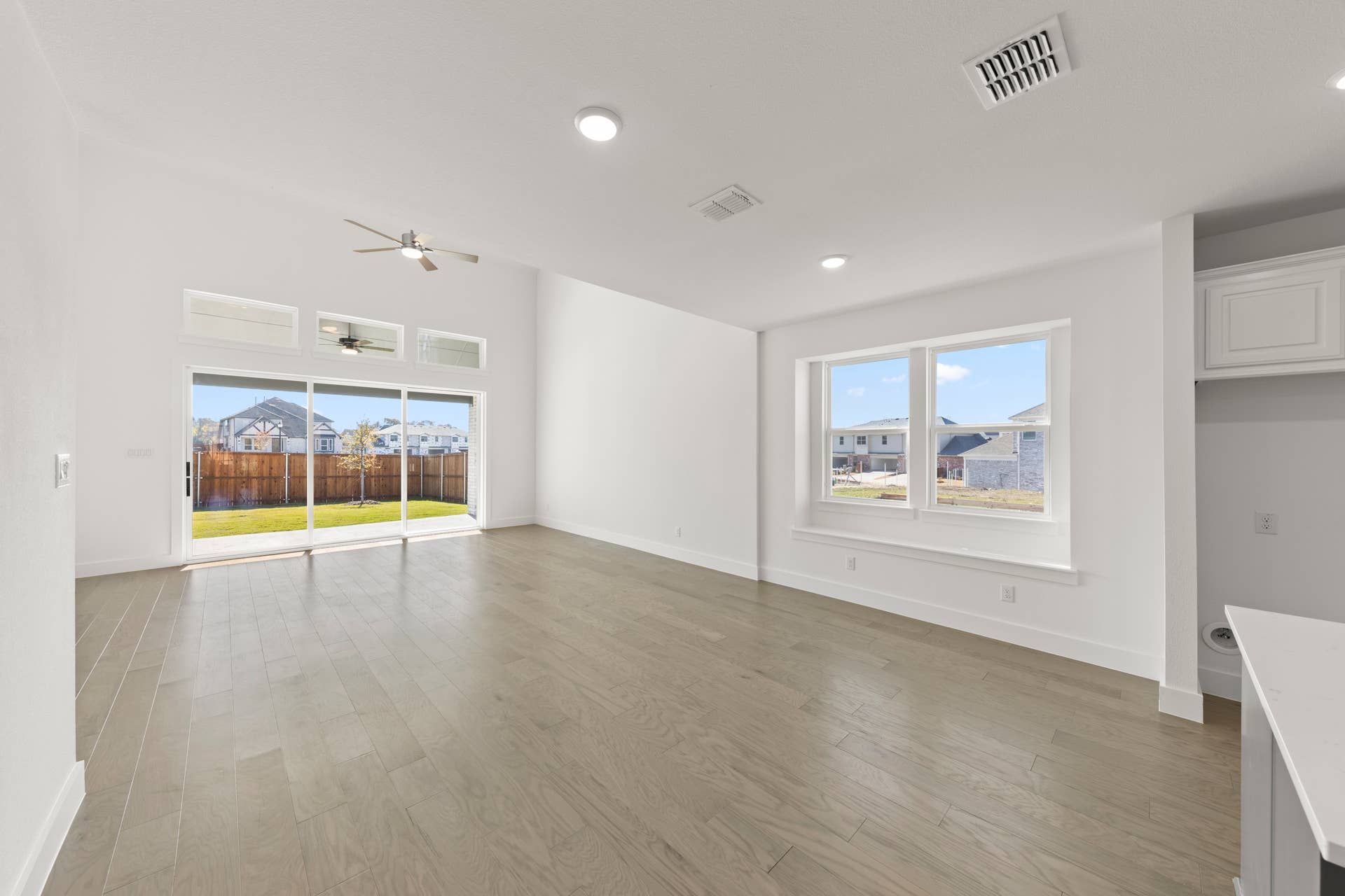 Spacious dining room with large windows and sliding glass door to backyard.