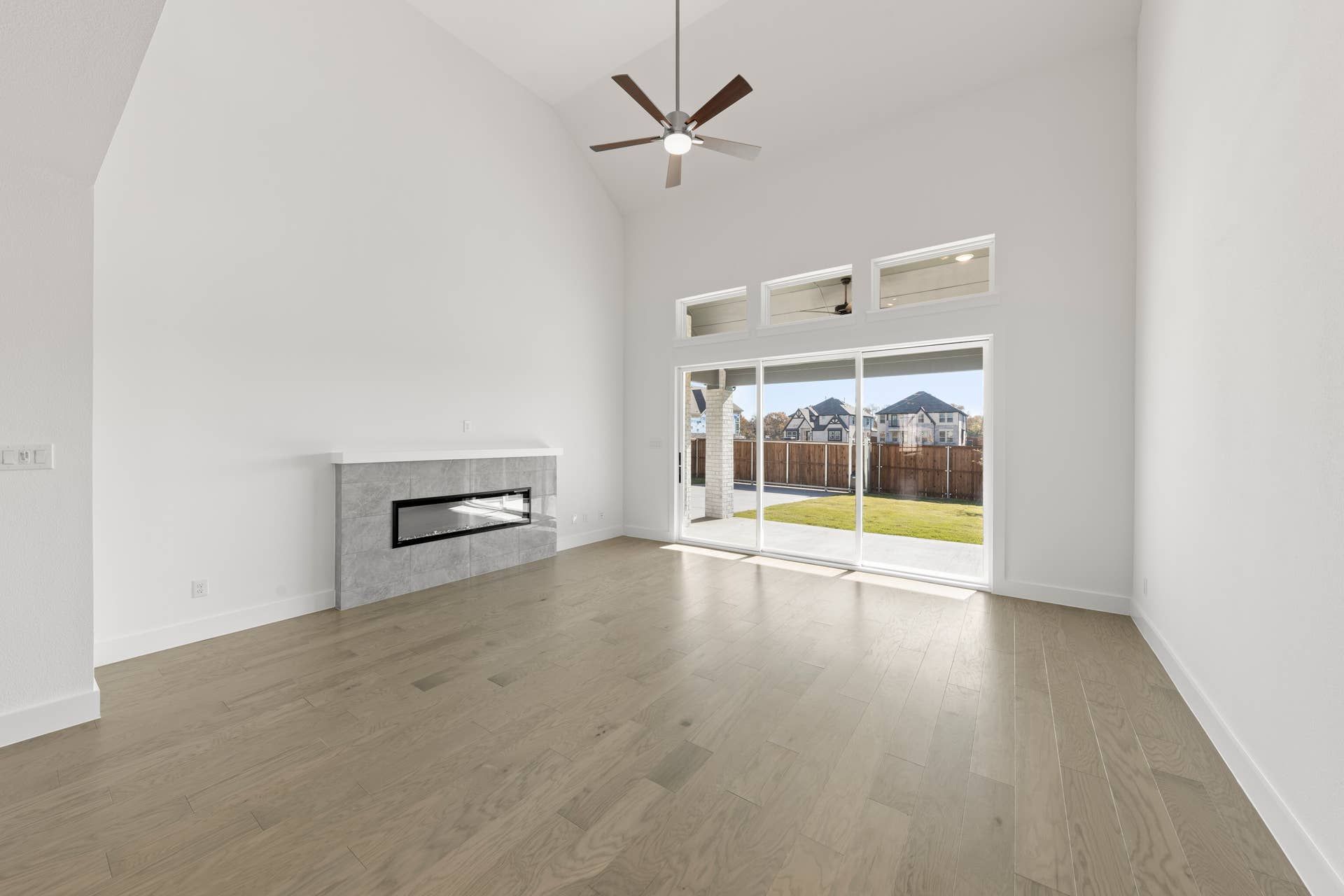 Bright living room with modern fireplace and large sliding glass doors.