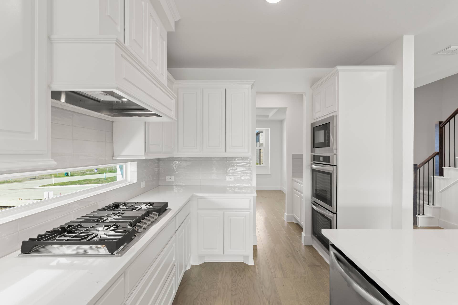 Modern kitchen with white cabinetry, sleek countertops, and stainless steel appliances.
