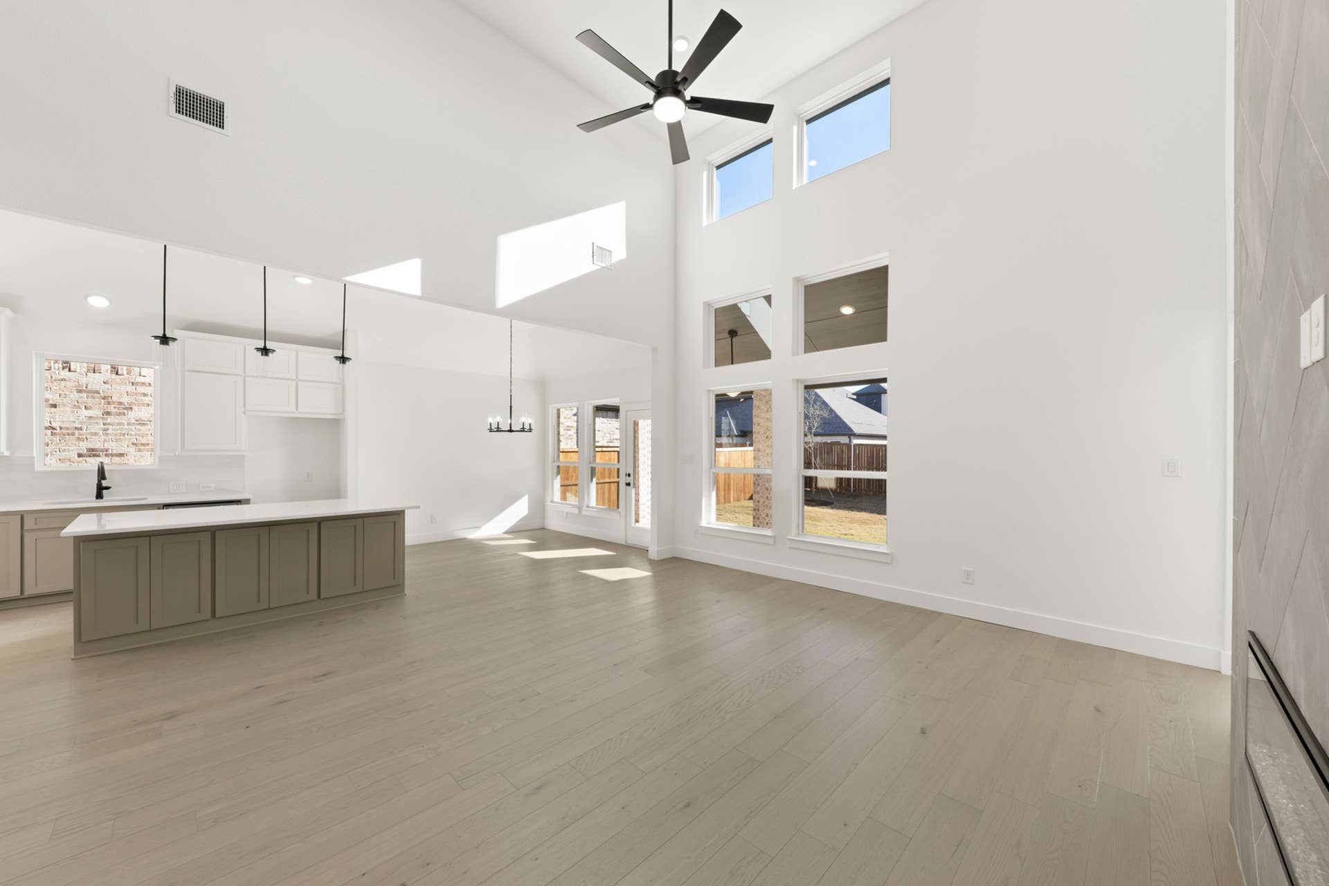 Spacious open-concept interior with high ceilings and large windows.