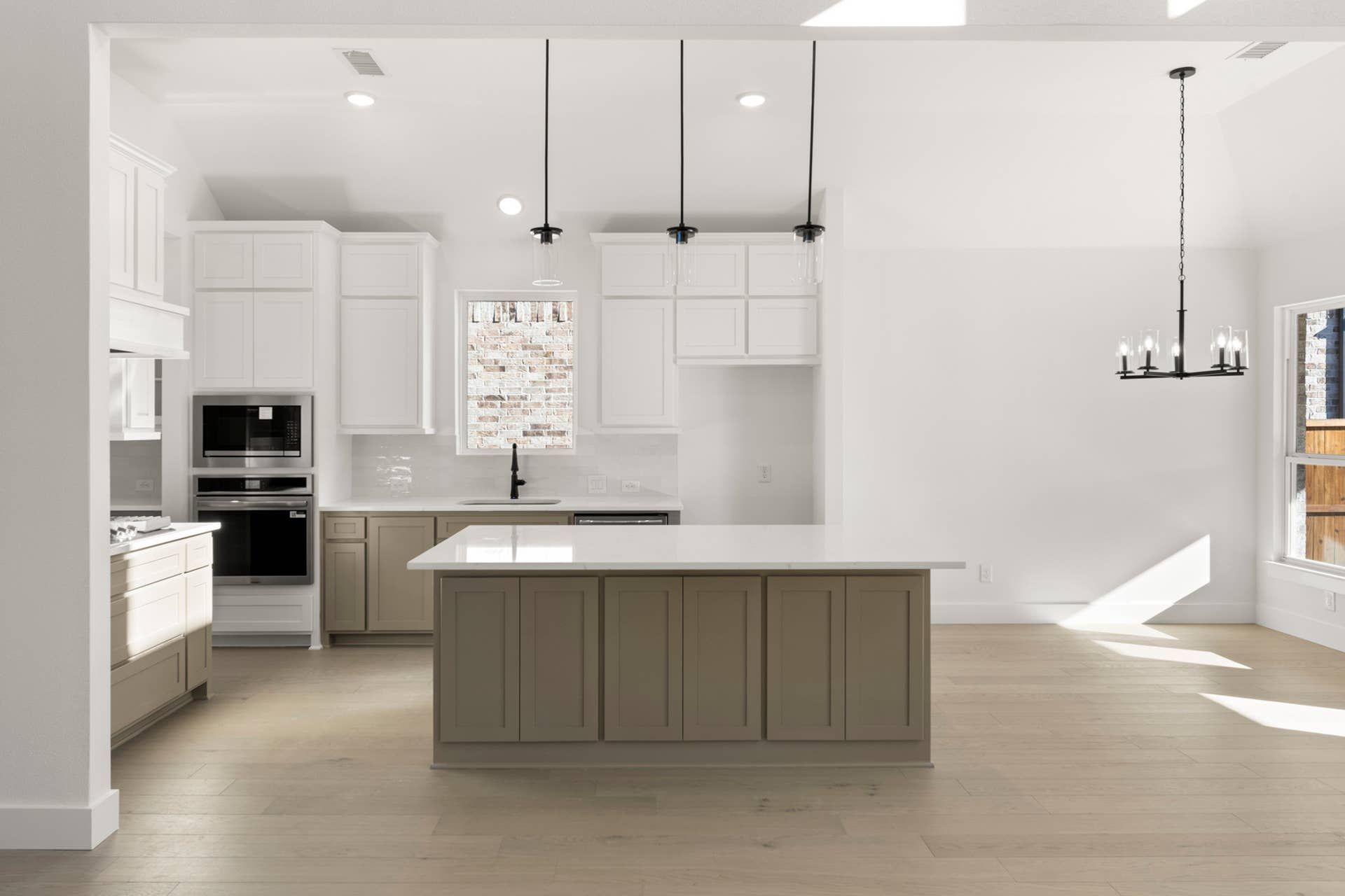 Modern kitchen with island, pendant lighting, and white cabinetry.