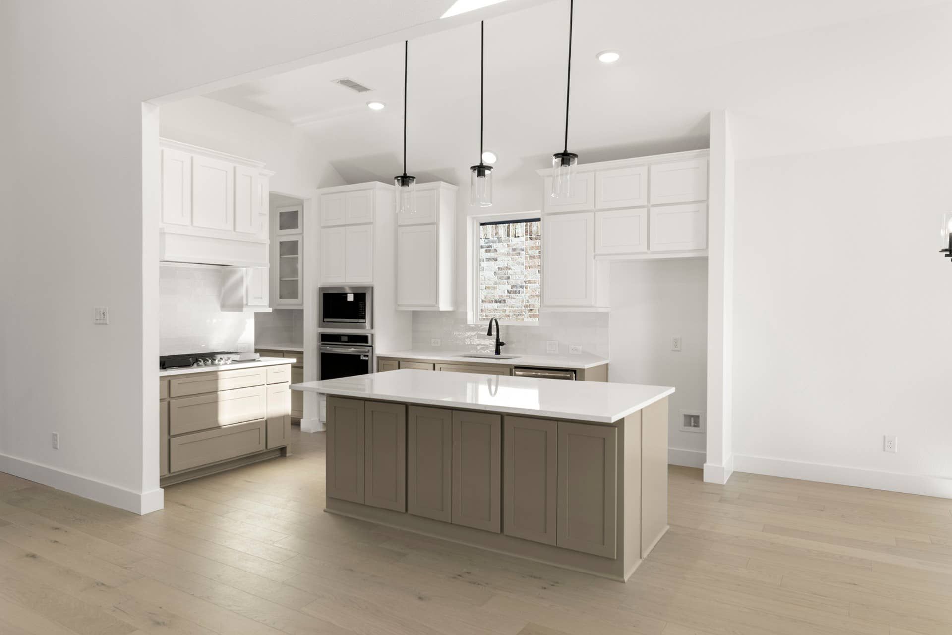 Modern kitchen with white cabinetry, island, and hardwood floors.