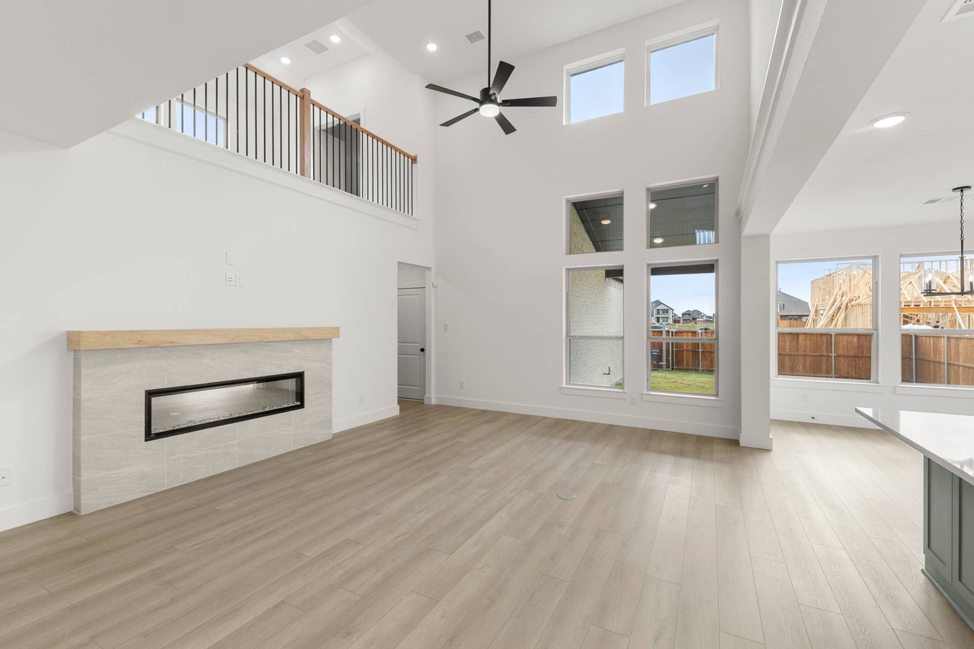 Spacious living room with high ceilings, large windows, and modern fireplace.