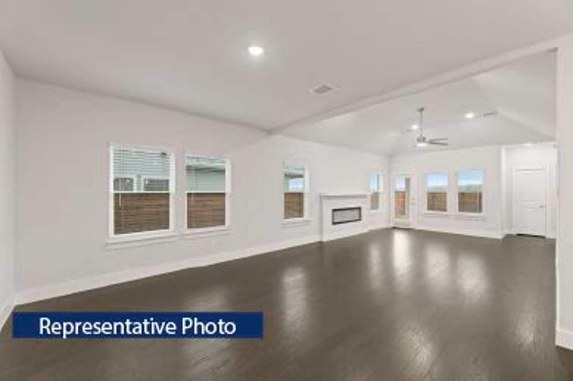 Representative photo of spacious open-concept living area with hardwood floors and fireplace.