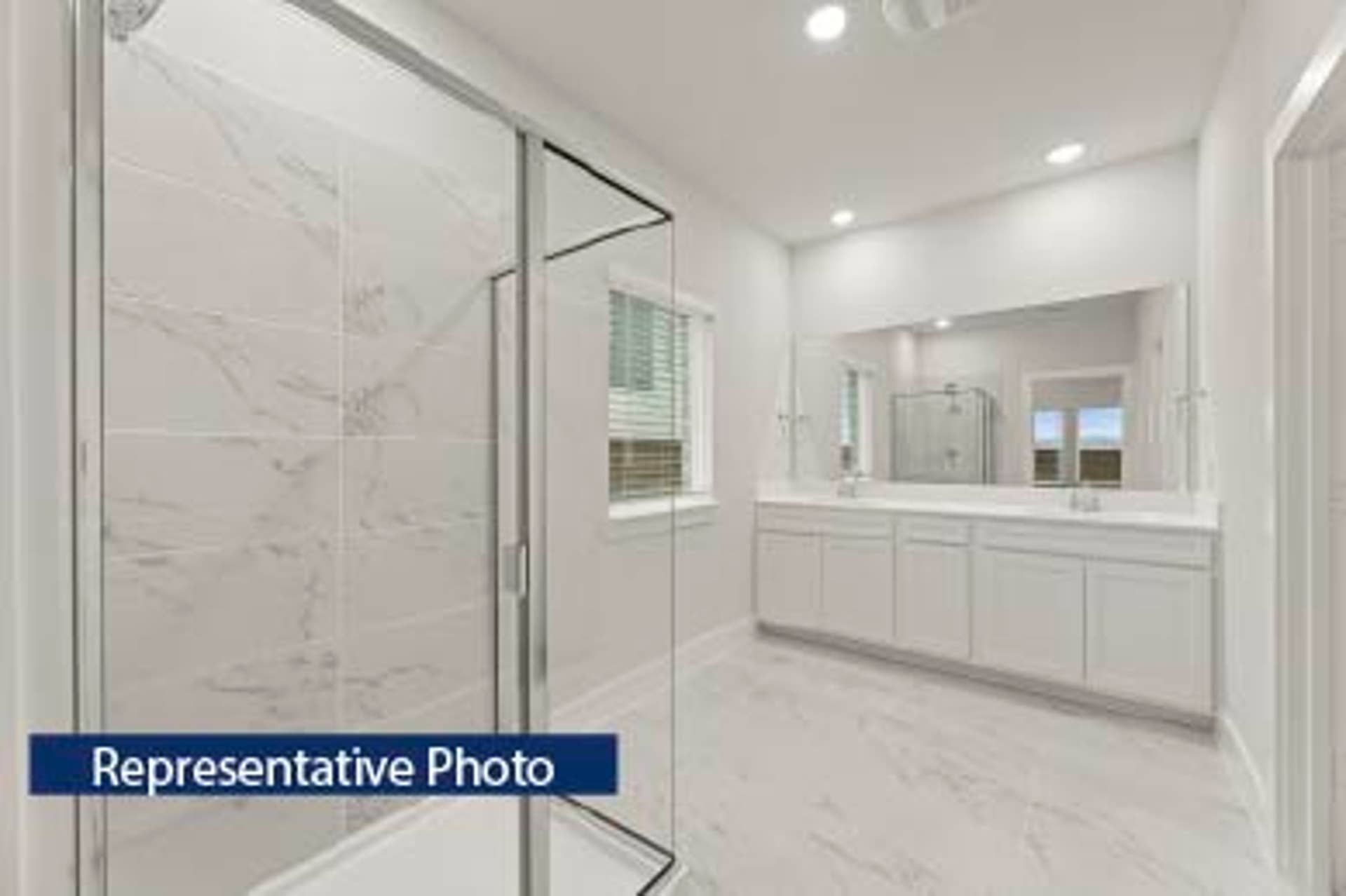 Representative photo of modern bathroom with glass shower and dual vanity.