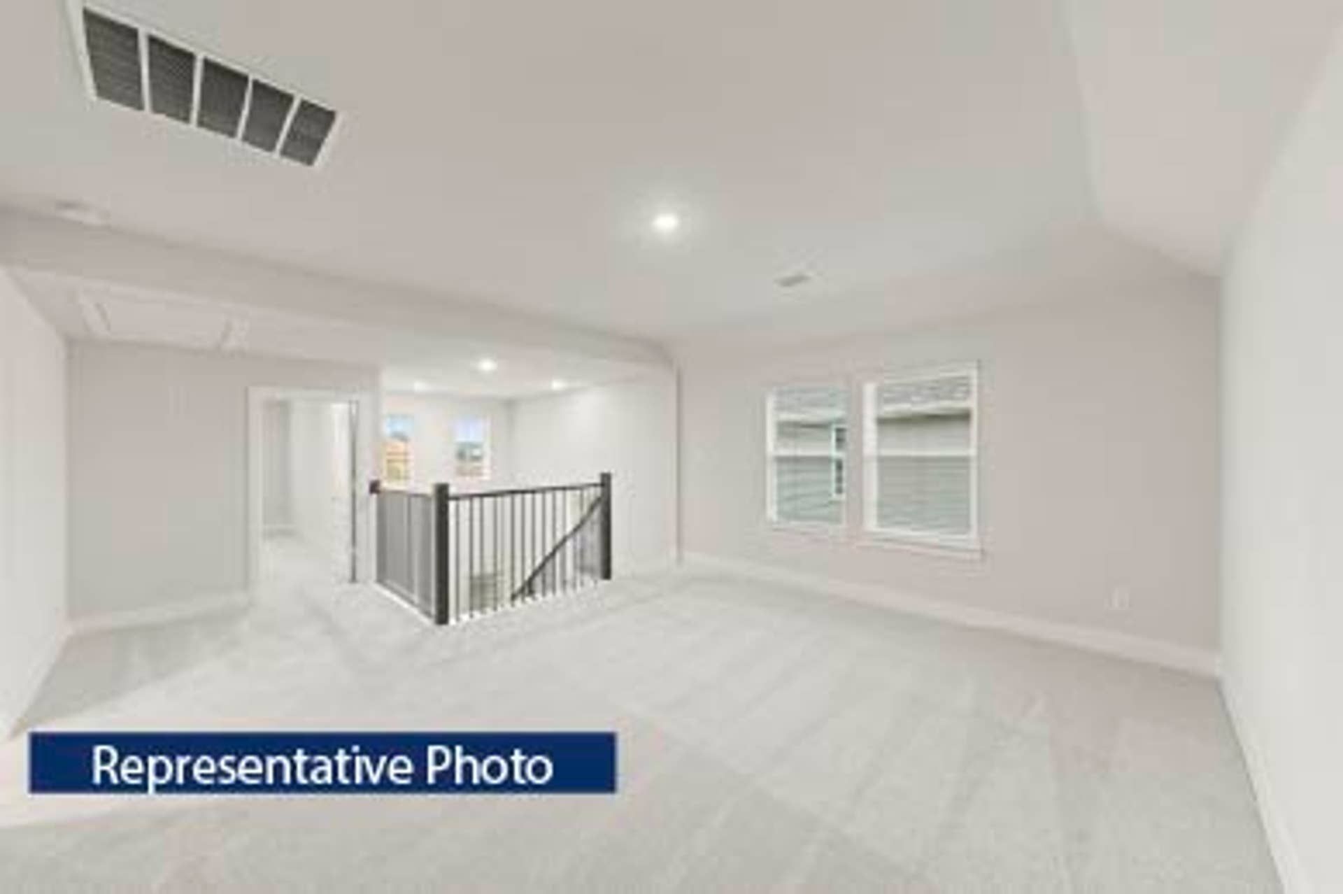 Representative photo of spacious, carpeted upper-level landing area with natural light.