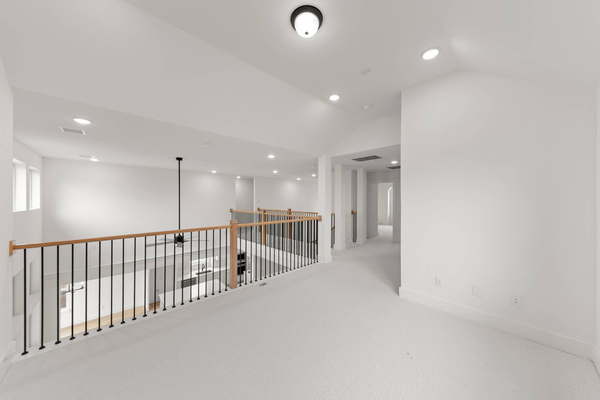 Spacious interior loft with railing overlooking lower level living space.
