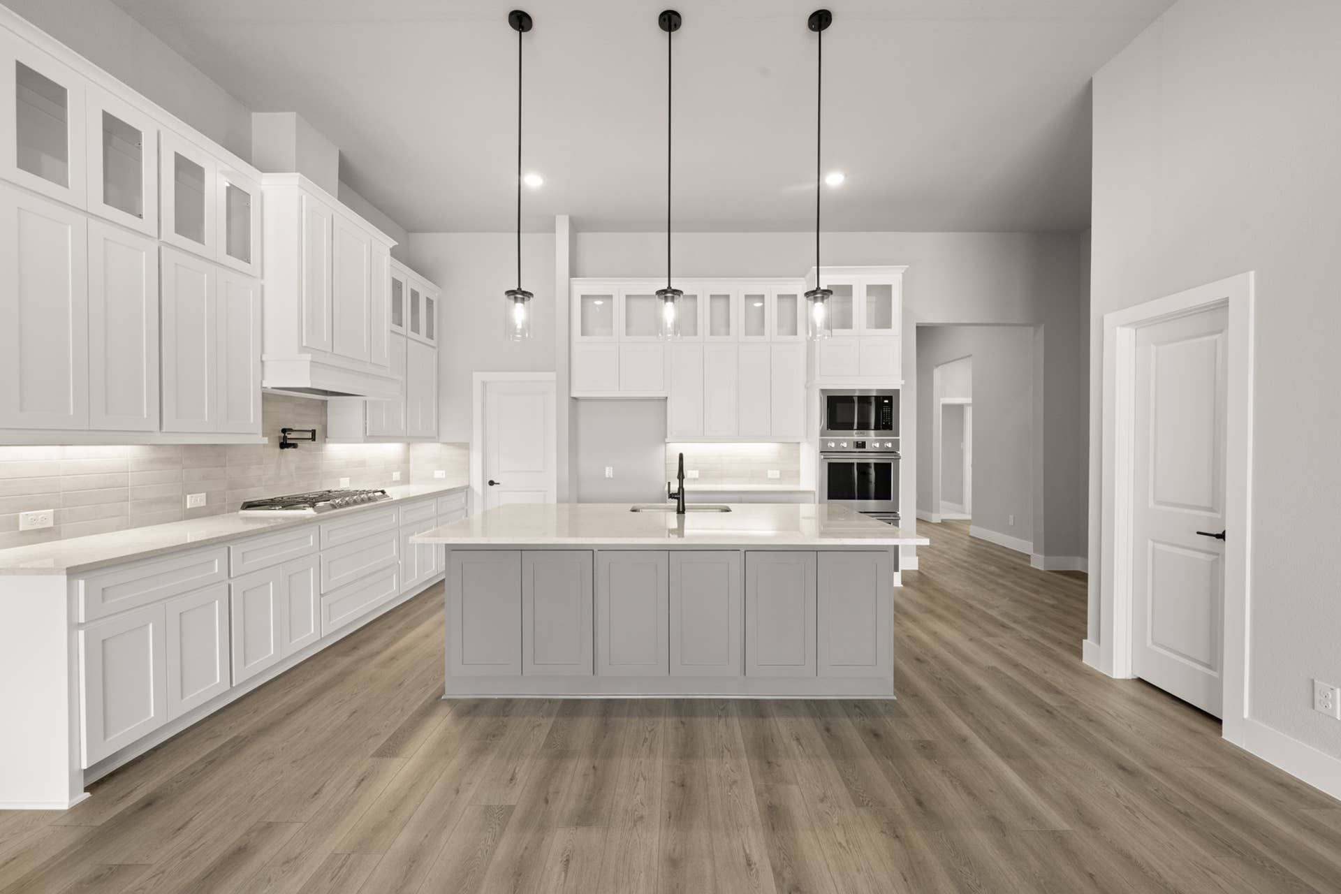Spacious modern kitchen with white cabinetry and large central island.