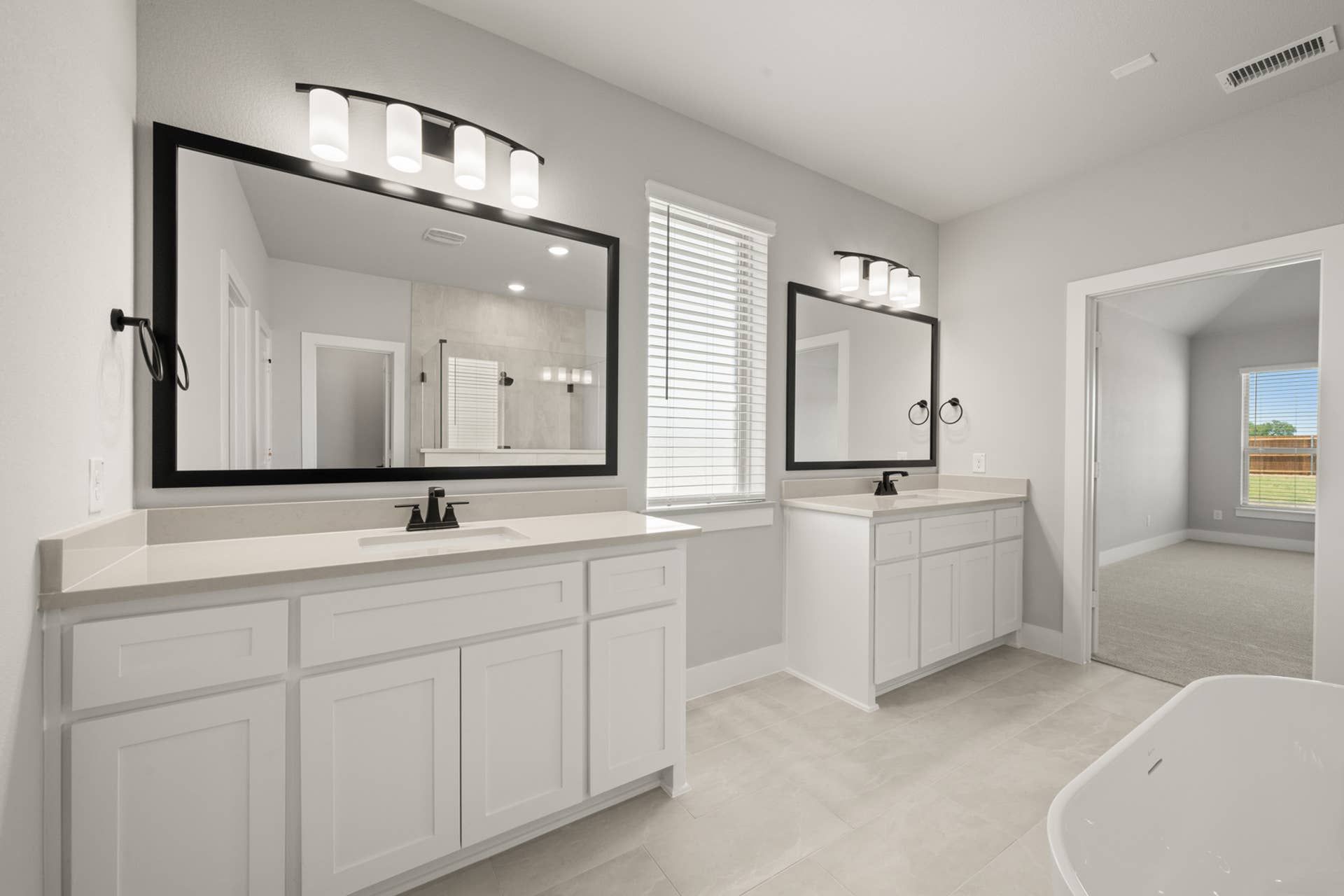 Elegant bathroom with dual sinks, large mirrors, and modern lighting.