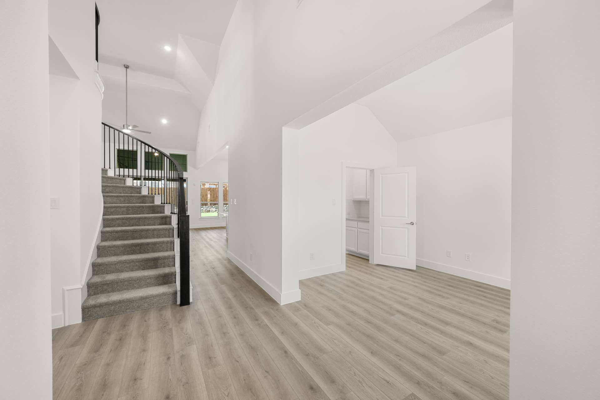 Elegant entryway with curved staircase and hardwood floors.