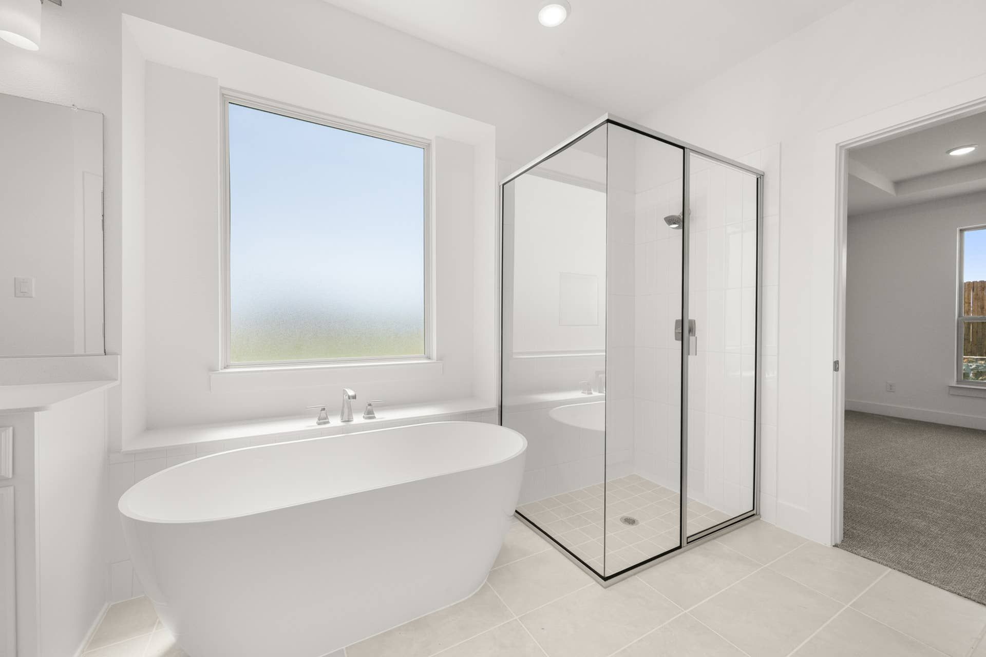 Modern bathroom with freestanding tub and glass-enclosed shower.