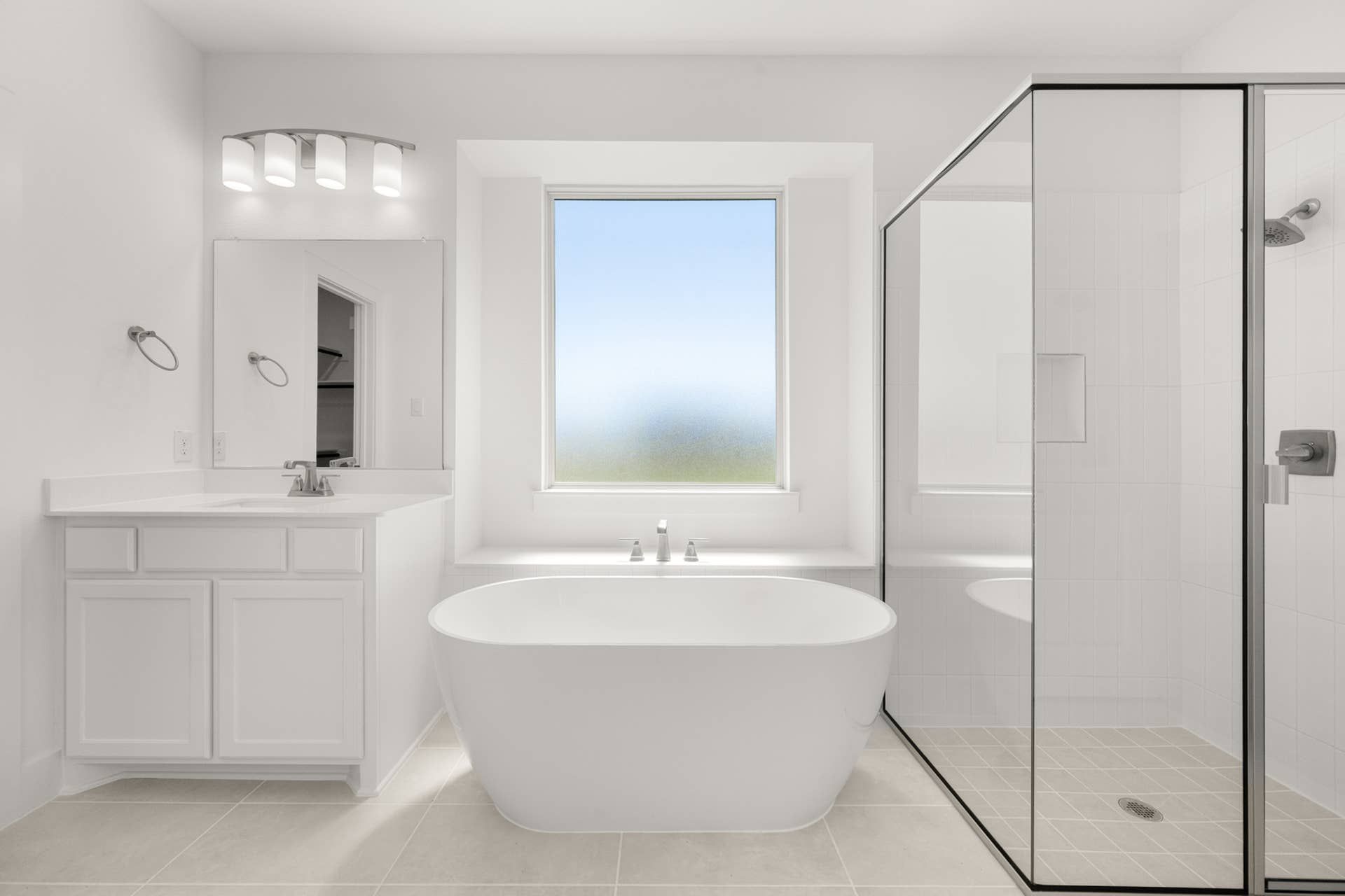 Modern bathroom with freestanding tub, glass shower, and large window.