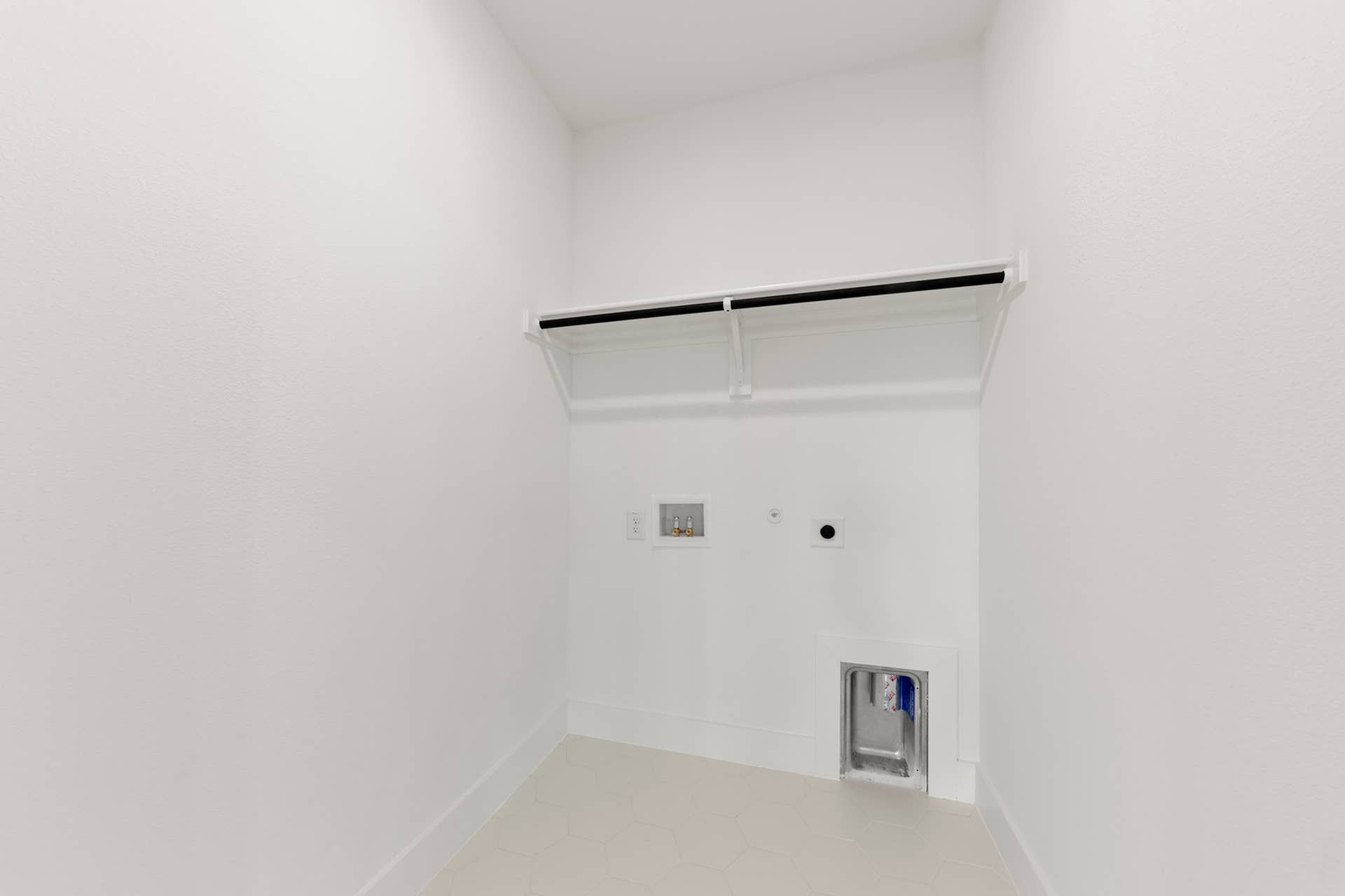 Spacious utility room with white walls and laundry hookups.