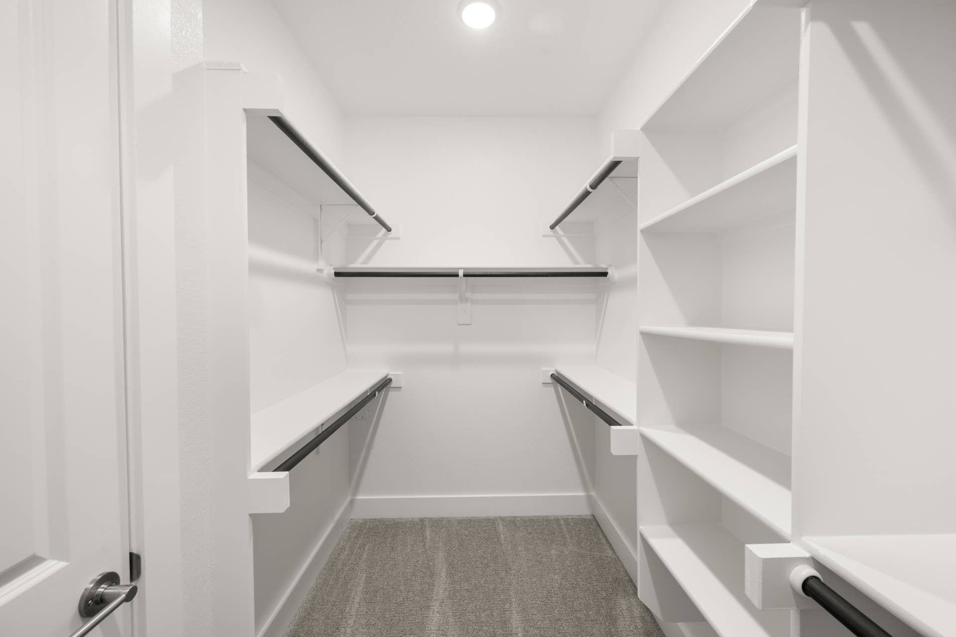 Spacious walk-in closet with shelves and hanging rods in primary suite.