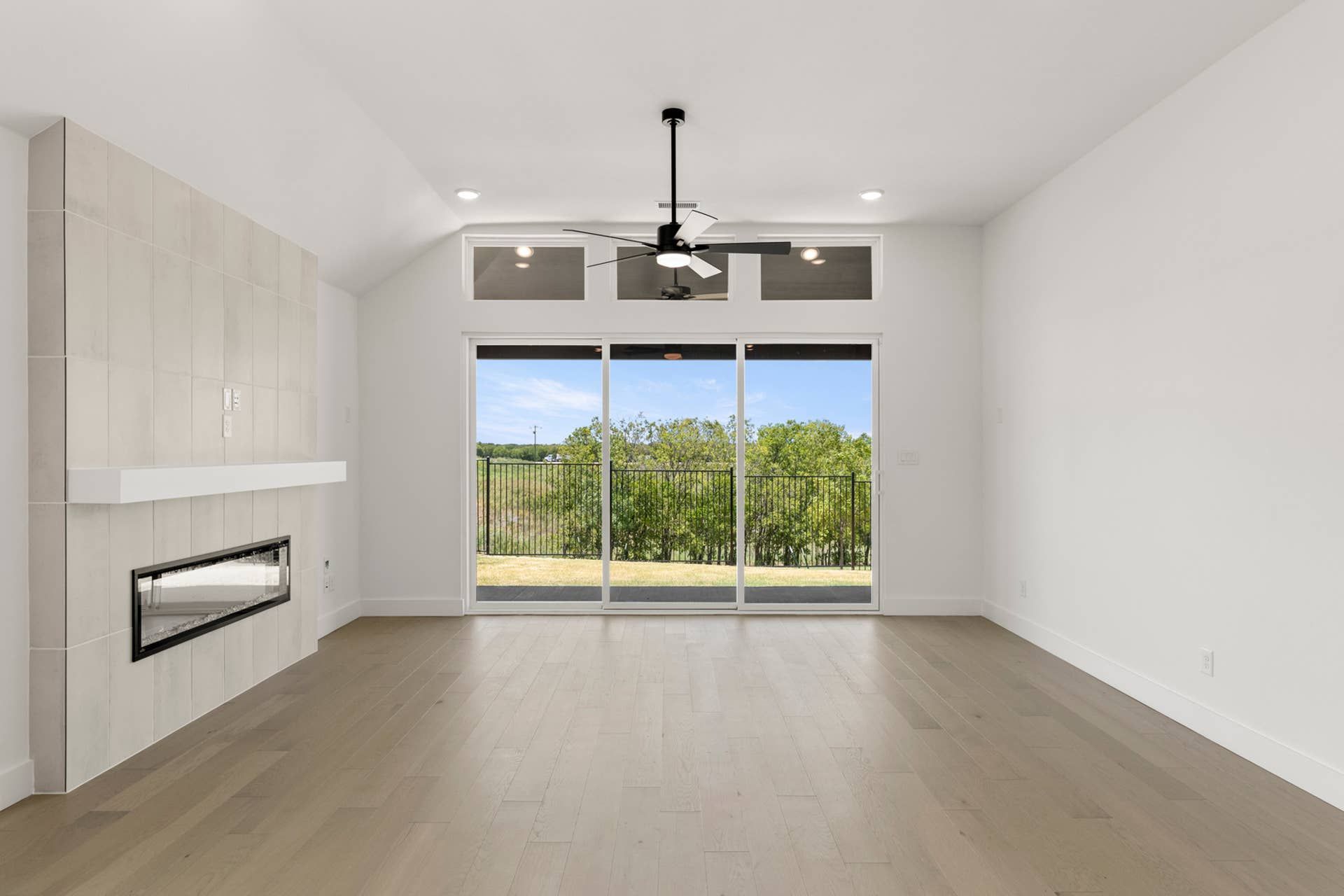 Spacious living room with modern fireplace and large sliding glass doors.