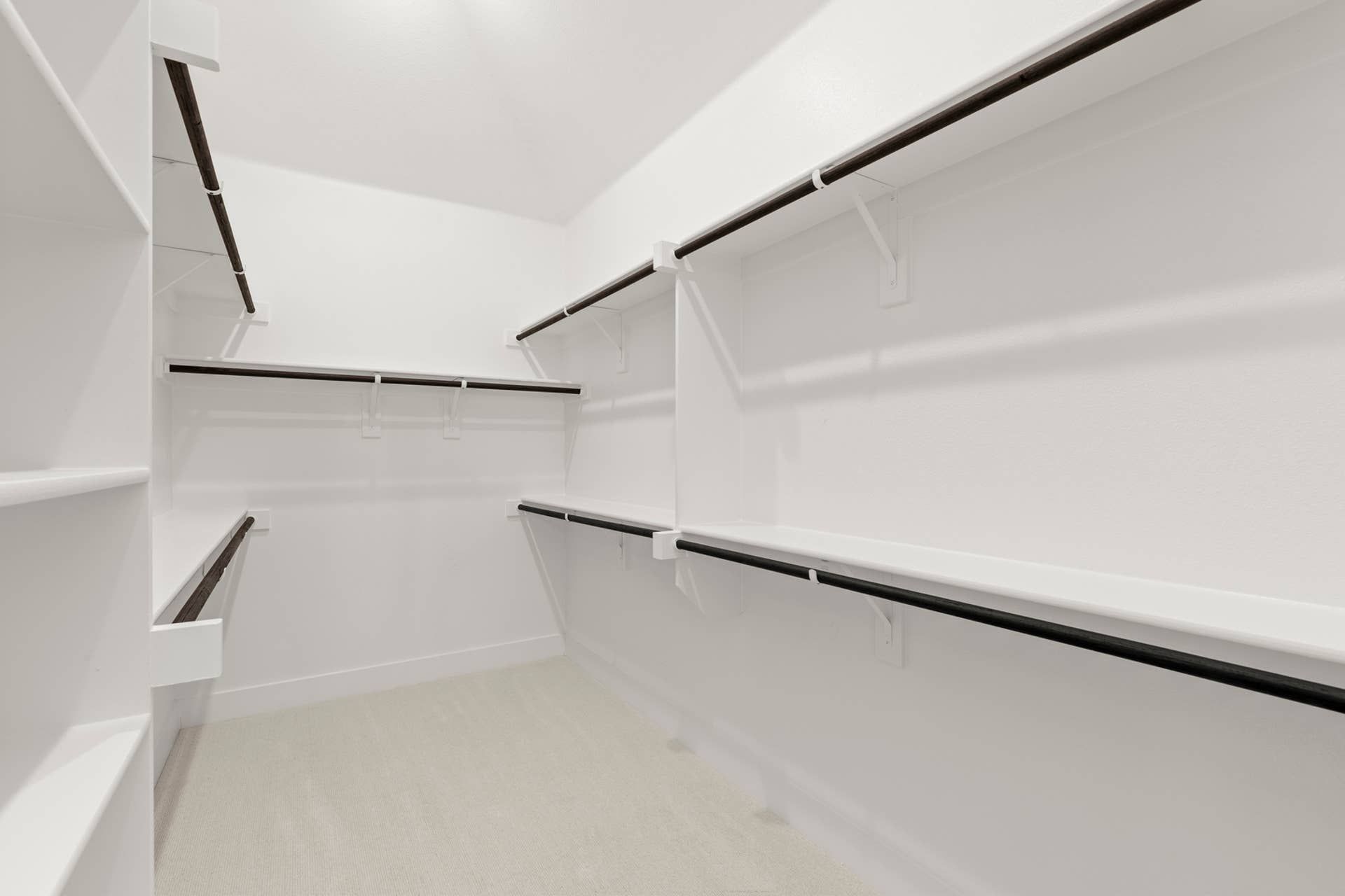 Spacious walk-in closet with multiple shelves and hanging rods.