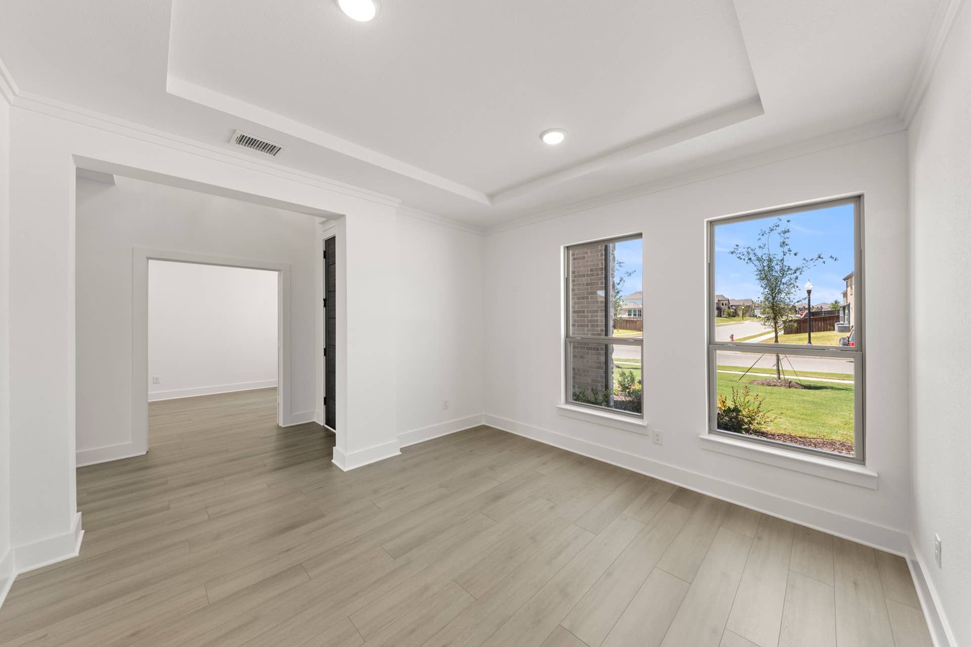 Bright dining room with large windows and light wood flooring.