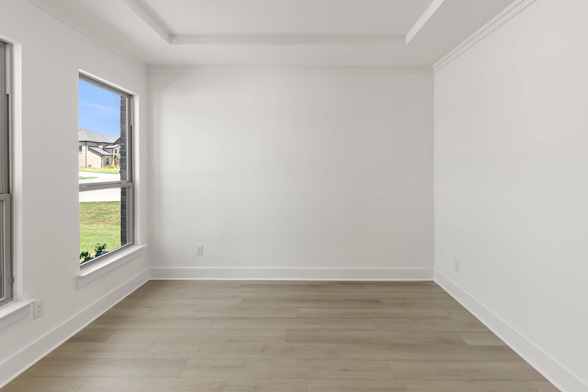 Bright dining room with large windows and light wood flooring.