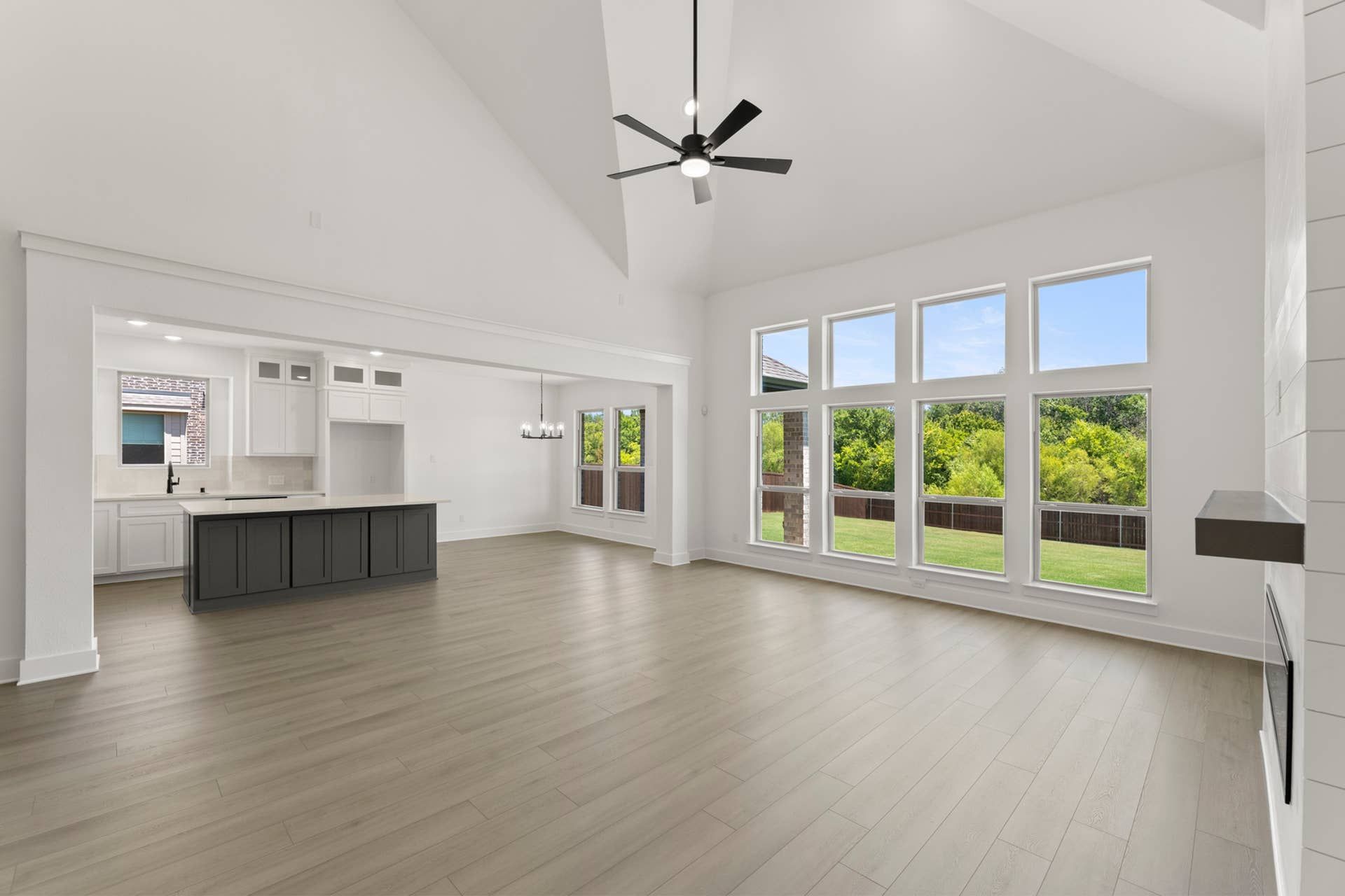 Spacious open-concept living area with large windows and modern kitchen design.