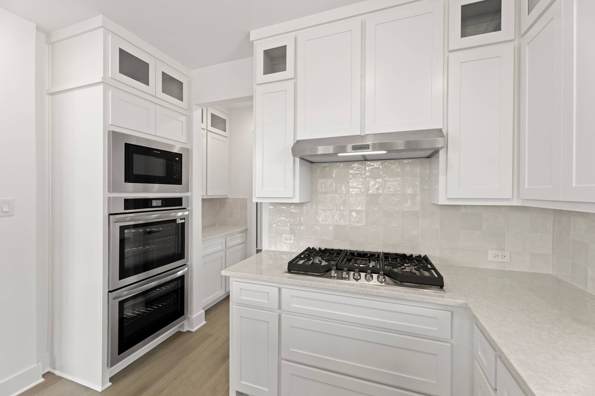 Modern kitchen with white cabinetry, stainless steel appliances, and gas cooktop.