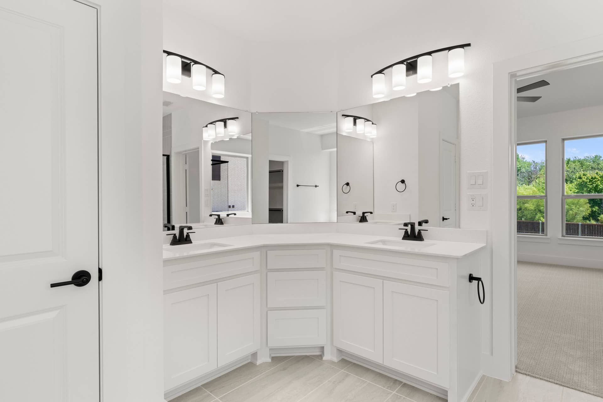 Modern bathroom with dual sinks, white cabinetry, and large mirror.