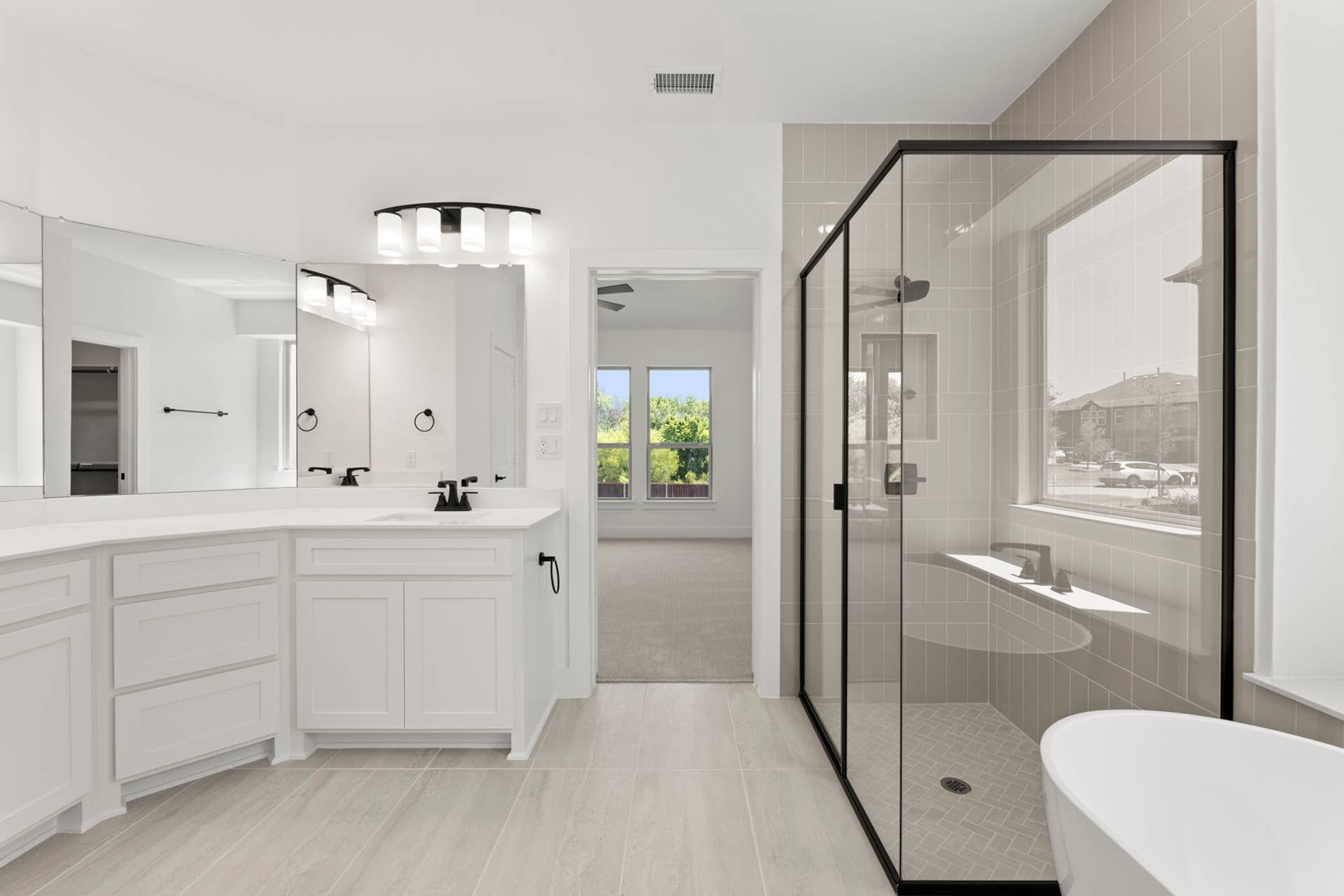 Modern bathroom with glass shower, dual sinks, and large mirror.