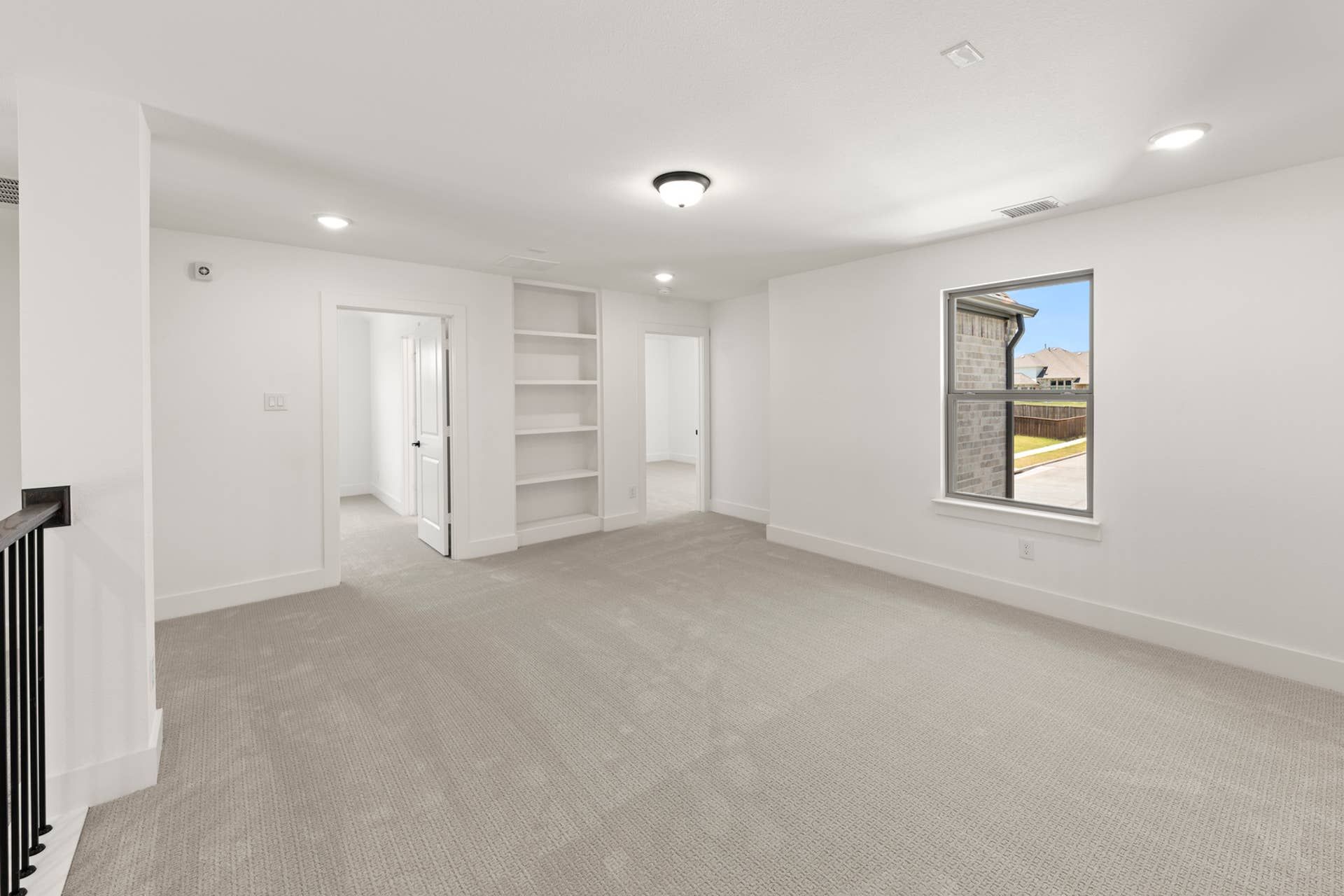 Spacious interior room with built-in shelves and large window view.