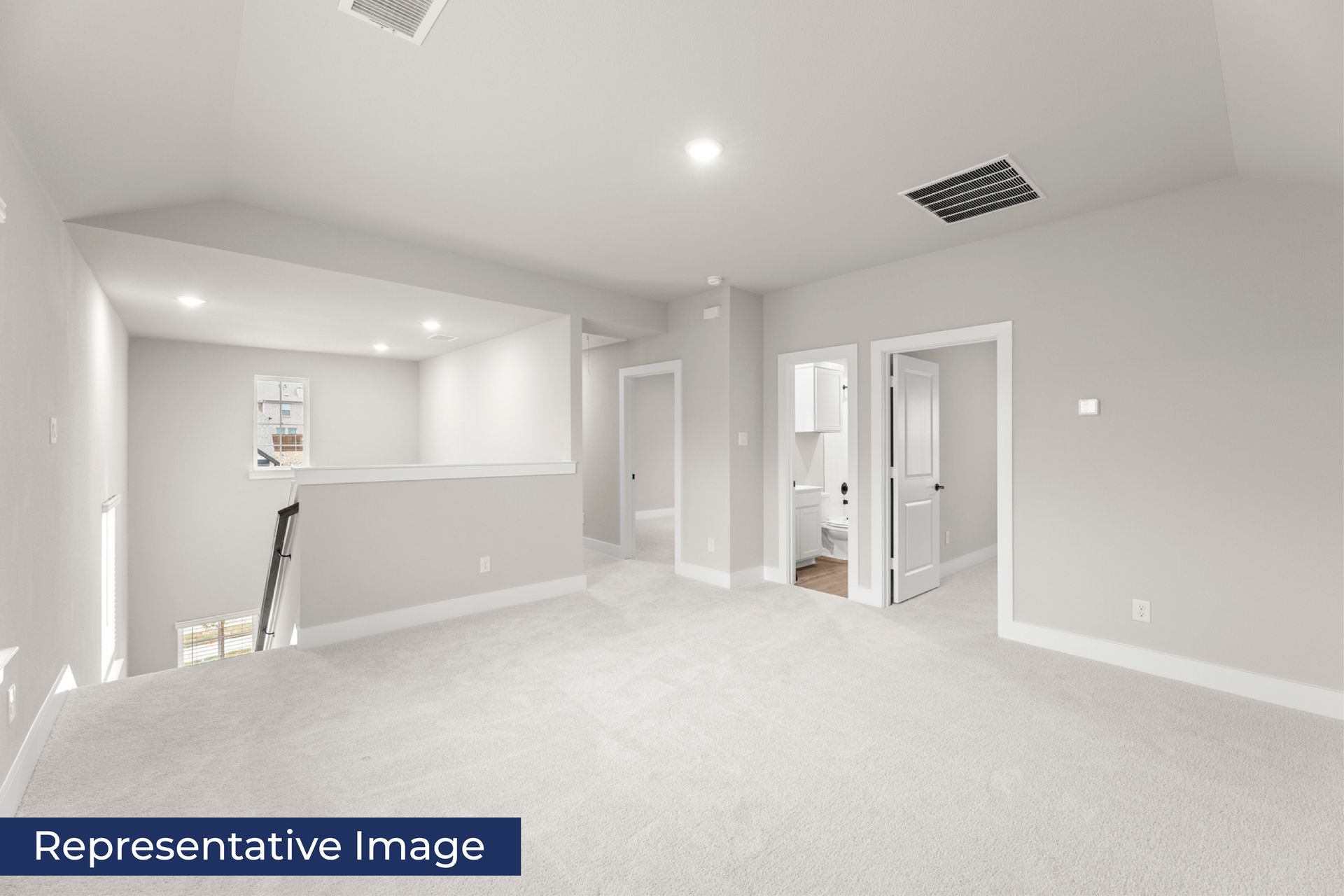 Spacious upstairs loft with carpet and adjacent bathroom in modern home.