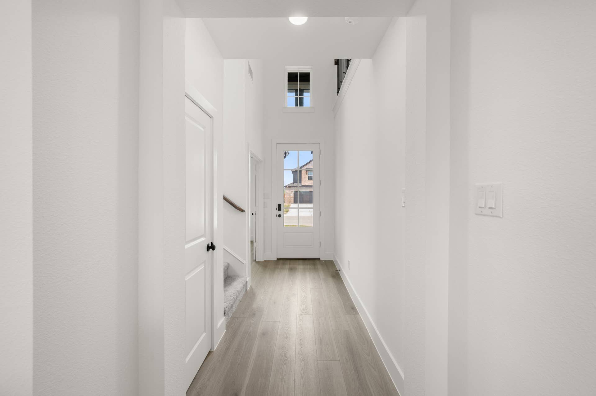 Bright entryway with wood flooring and modern door design.