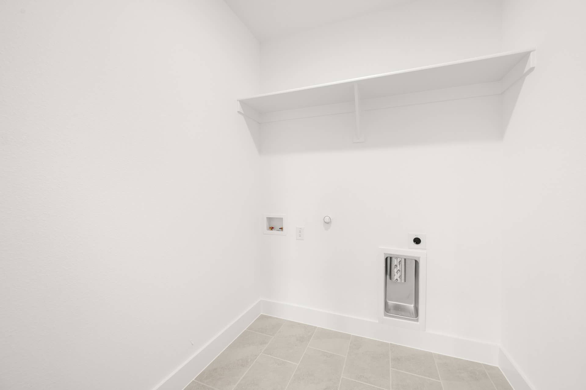 Minimalist utility room with wall shelf and washing machine hookups.