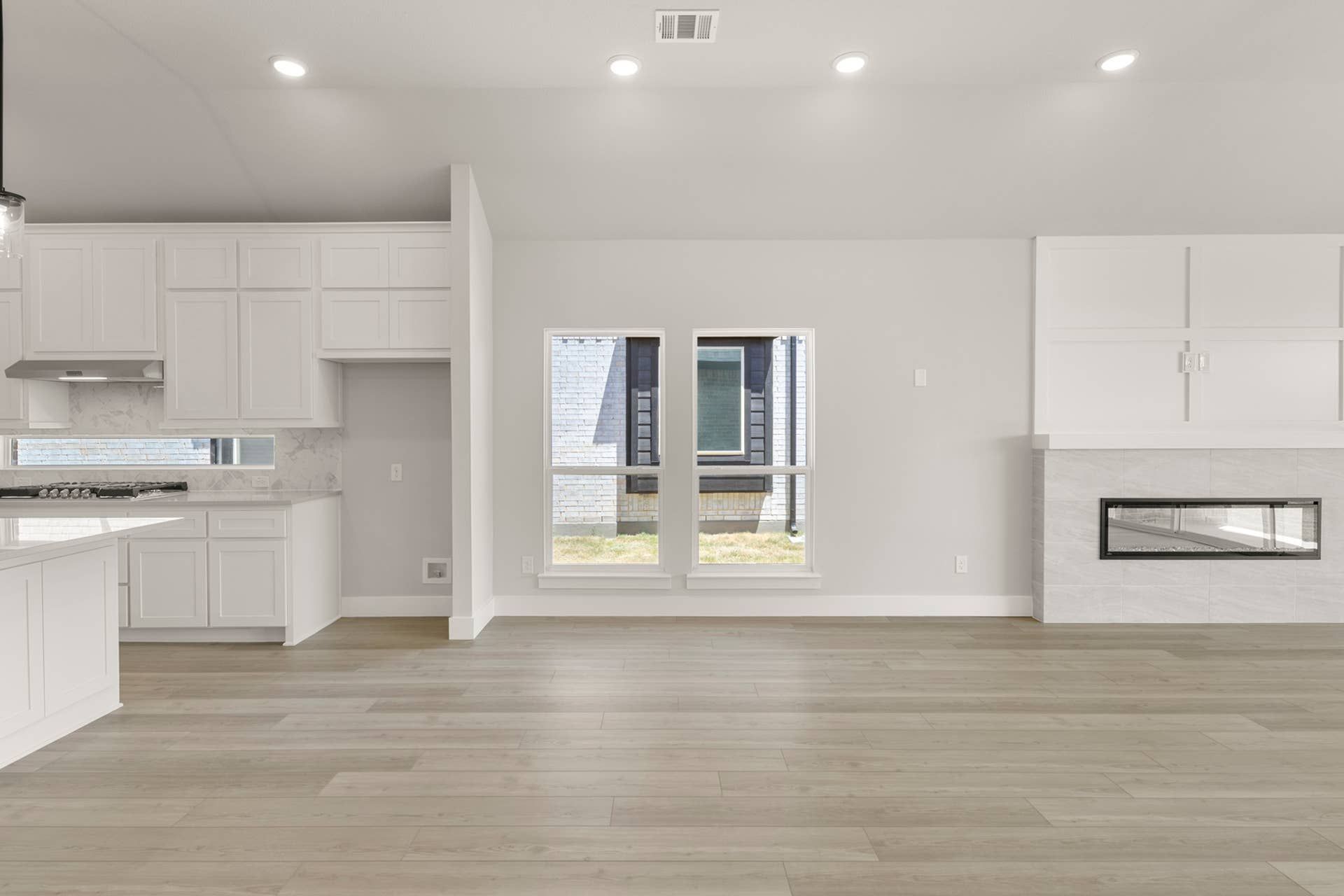 Spacious modern dining room with wood flooring and built-in fireplace.