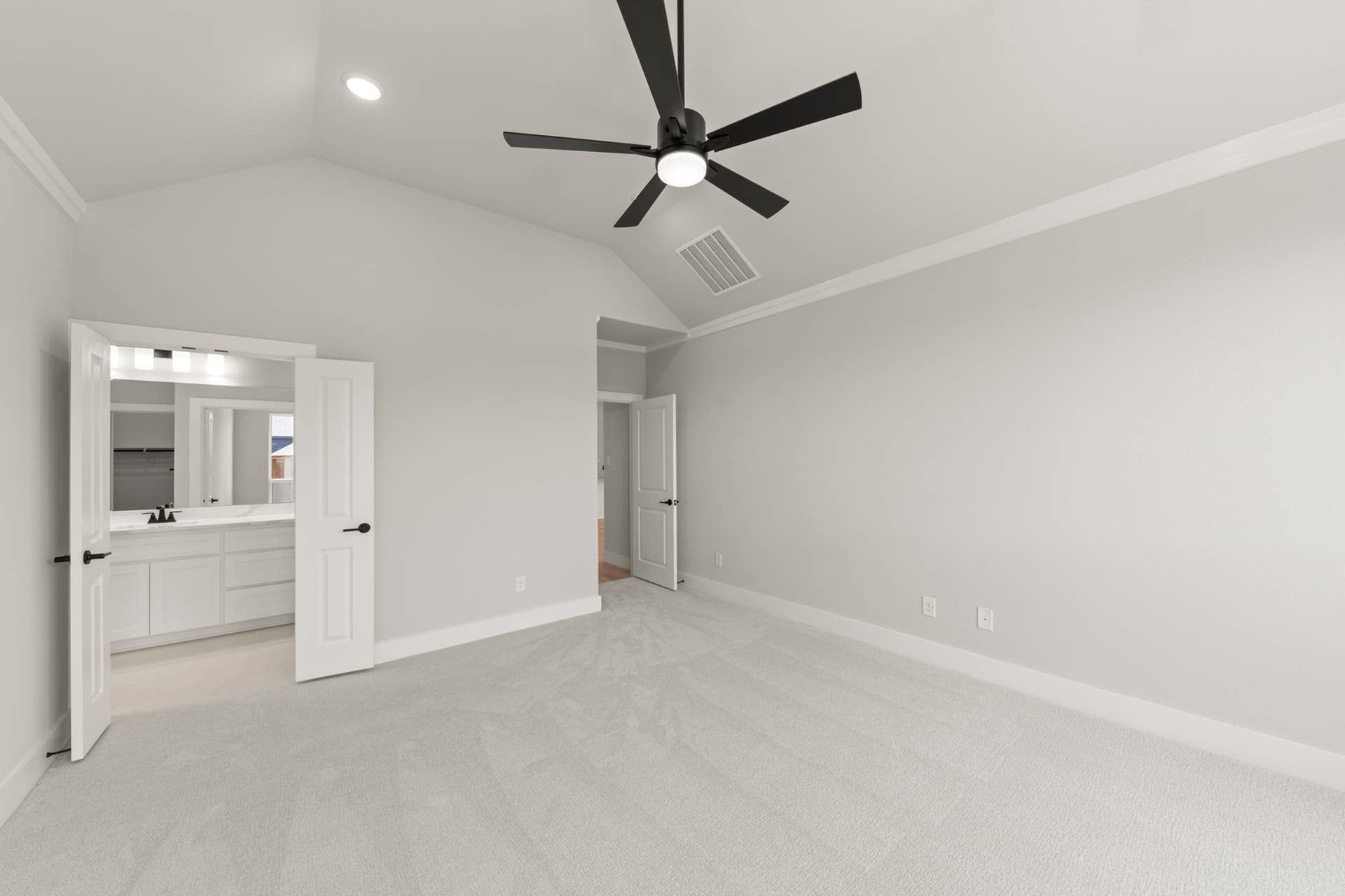Spacious bedroom with vaulted ceiling and ensuite bathroom.