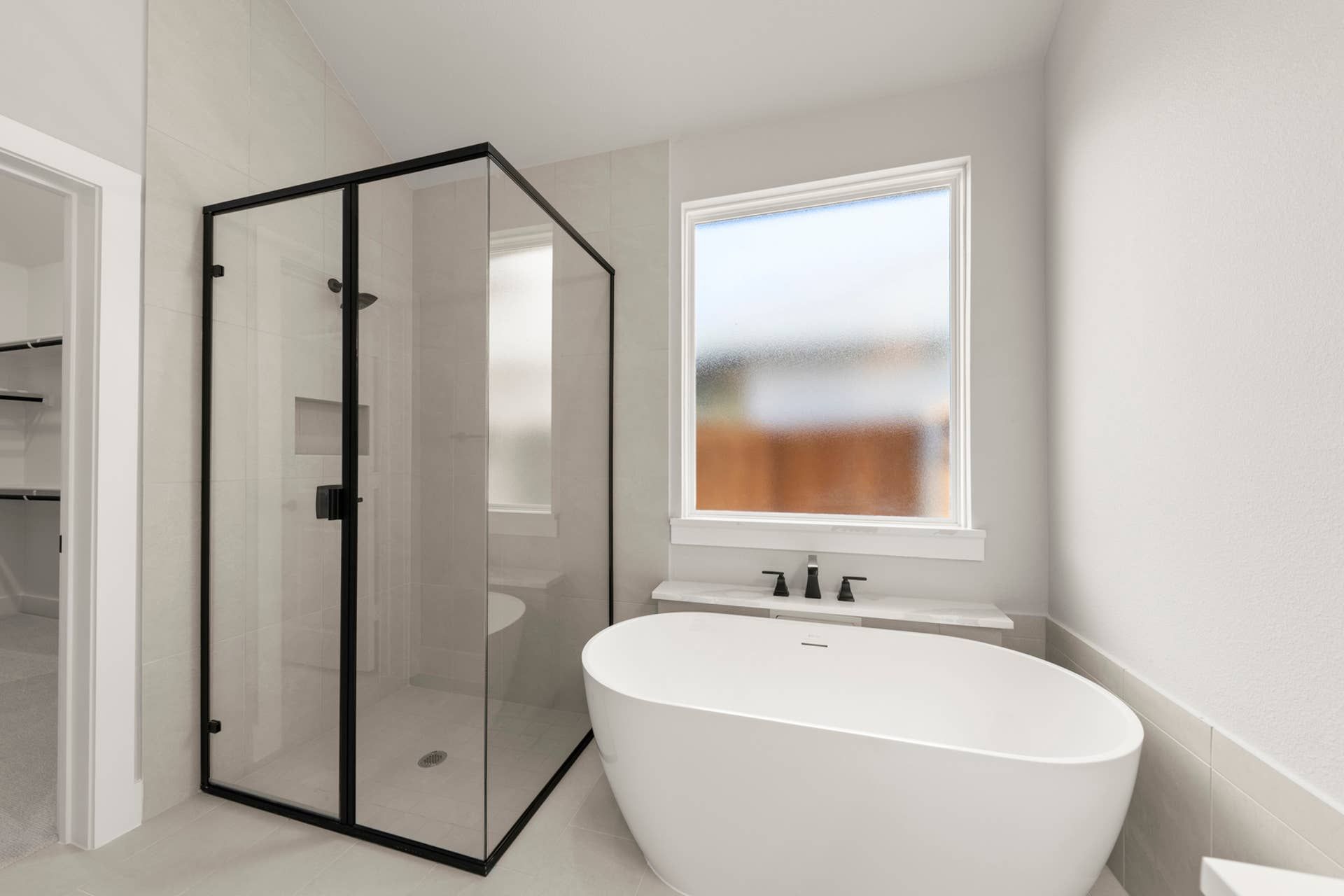Modern bathroom with freestanding tub and glass-enclosed shower.