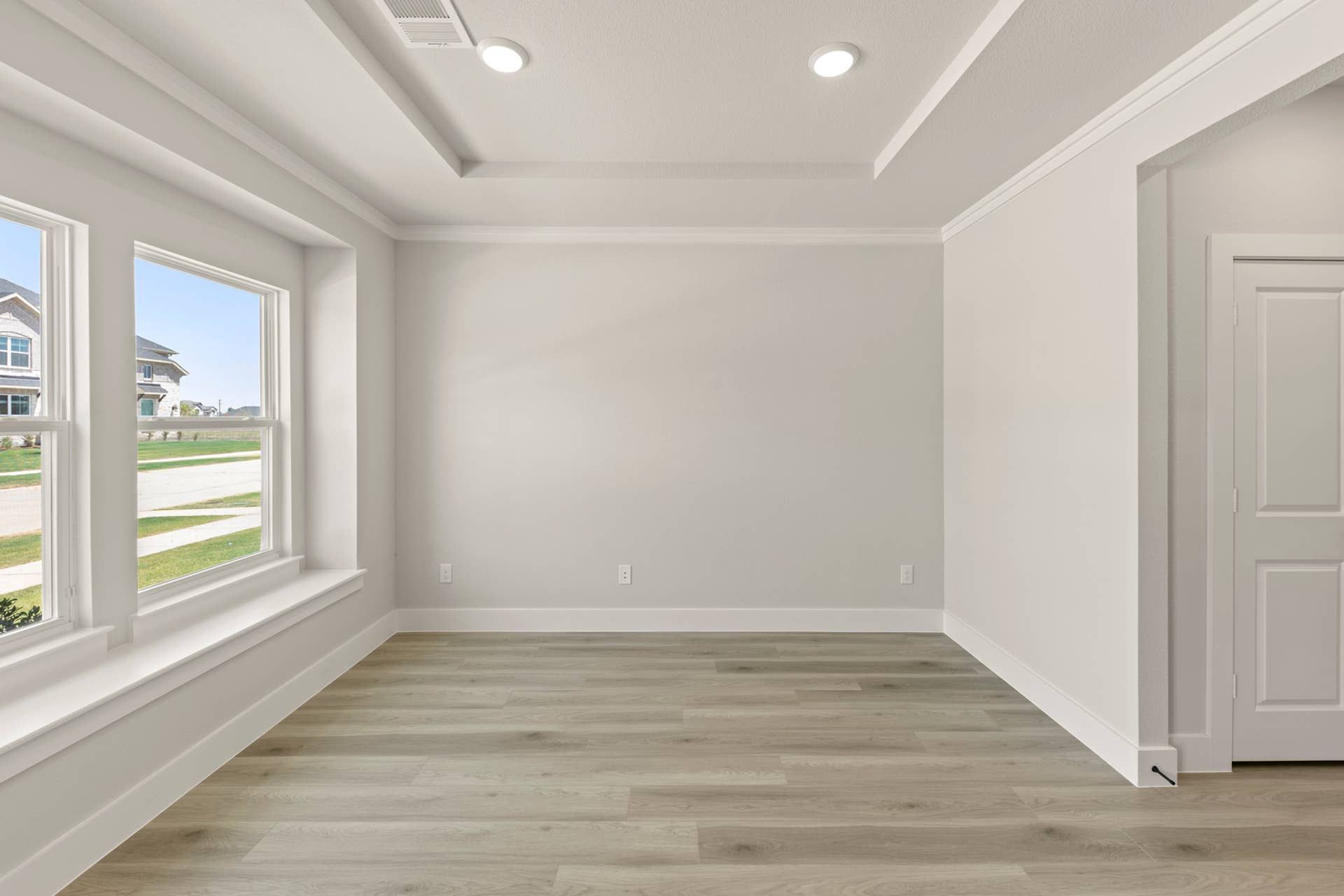 Spacious dining room with large windows and tray ceiling.