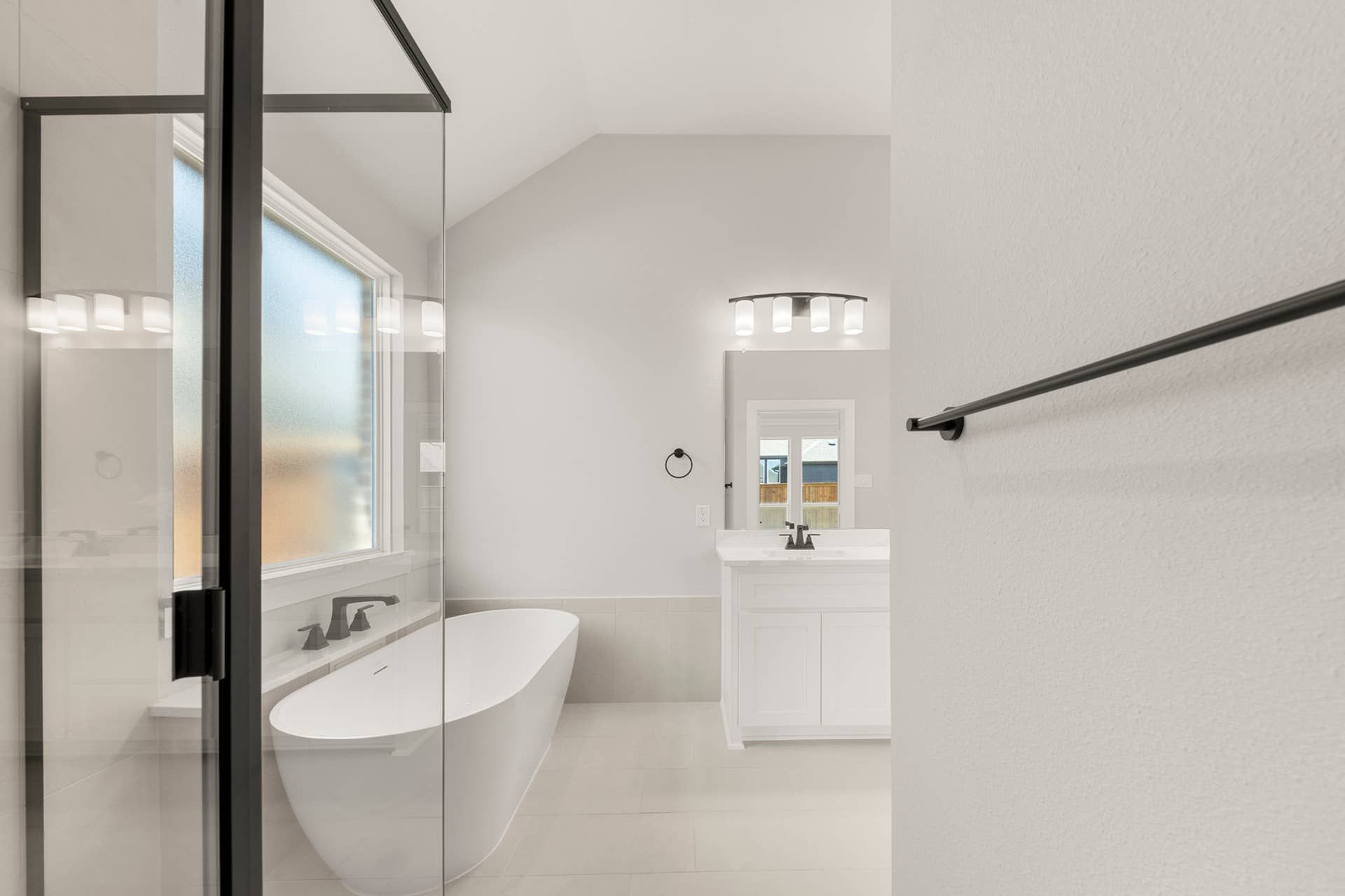 Modern bathroom with freestanding tub, glass shower, and sleek vanity.