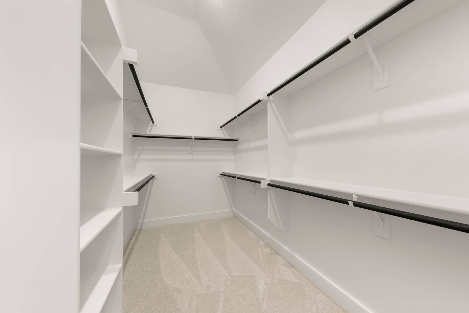 Spacious walk-in closet with multiple shelves and hanging rods.