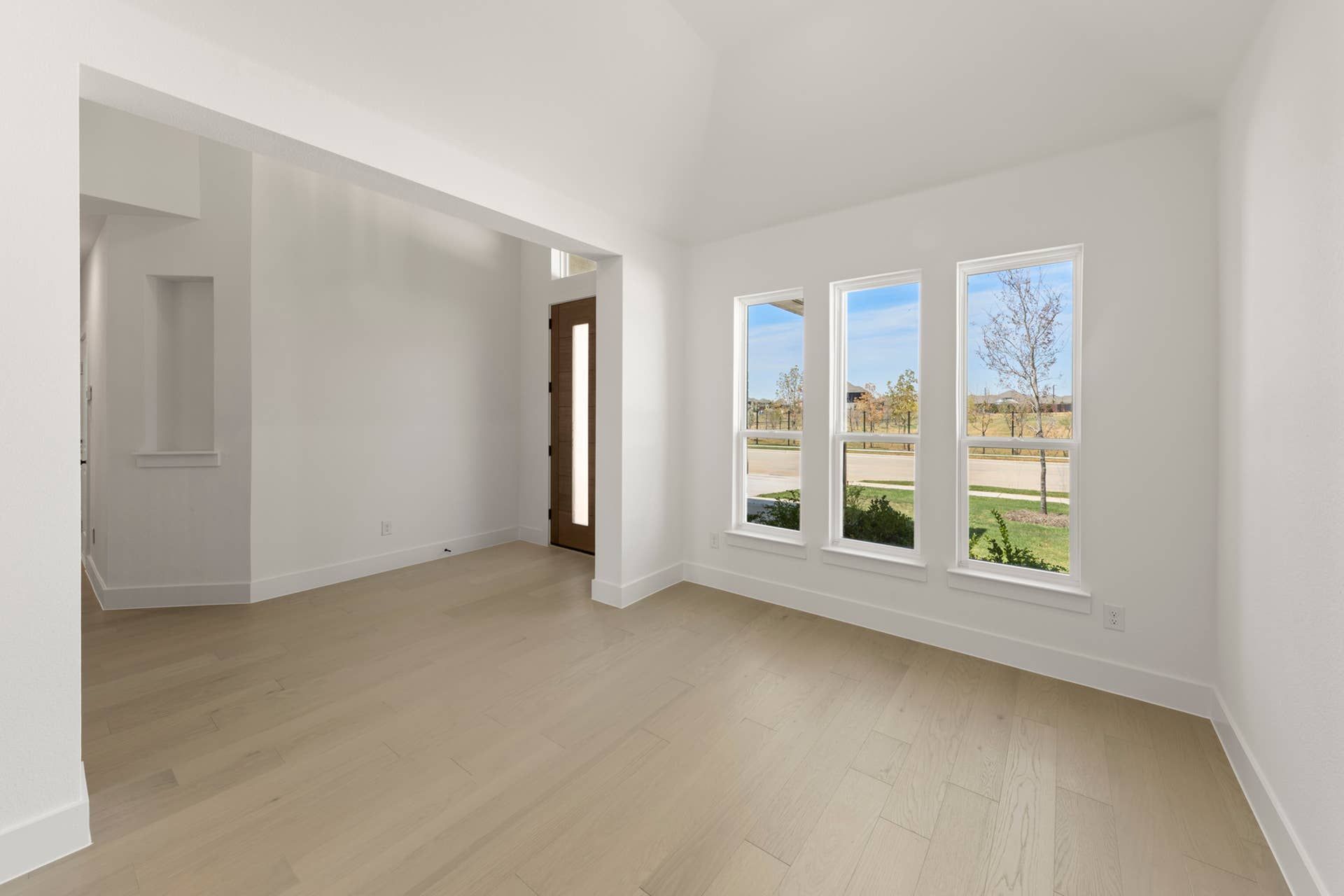 Bright dining area with wooden floors and large windows overlooking the outdoors.
