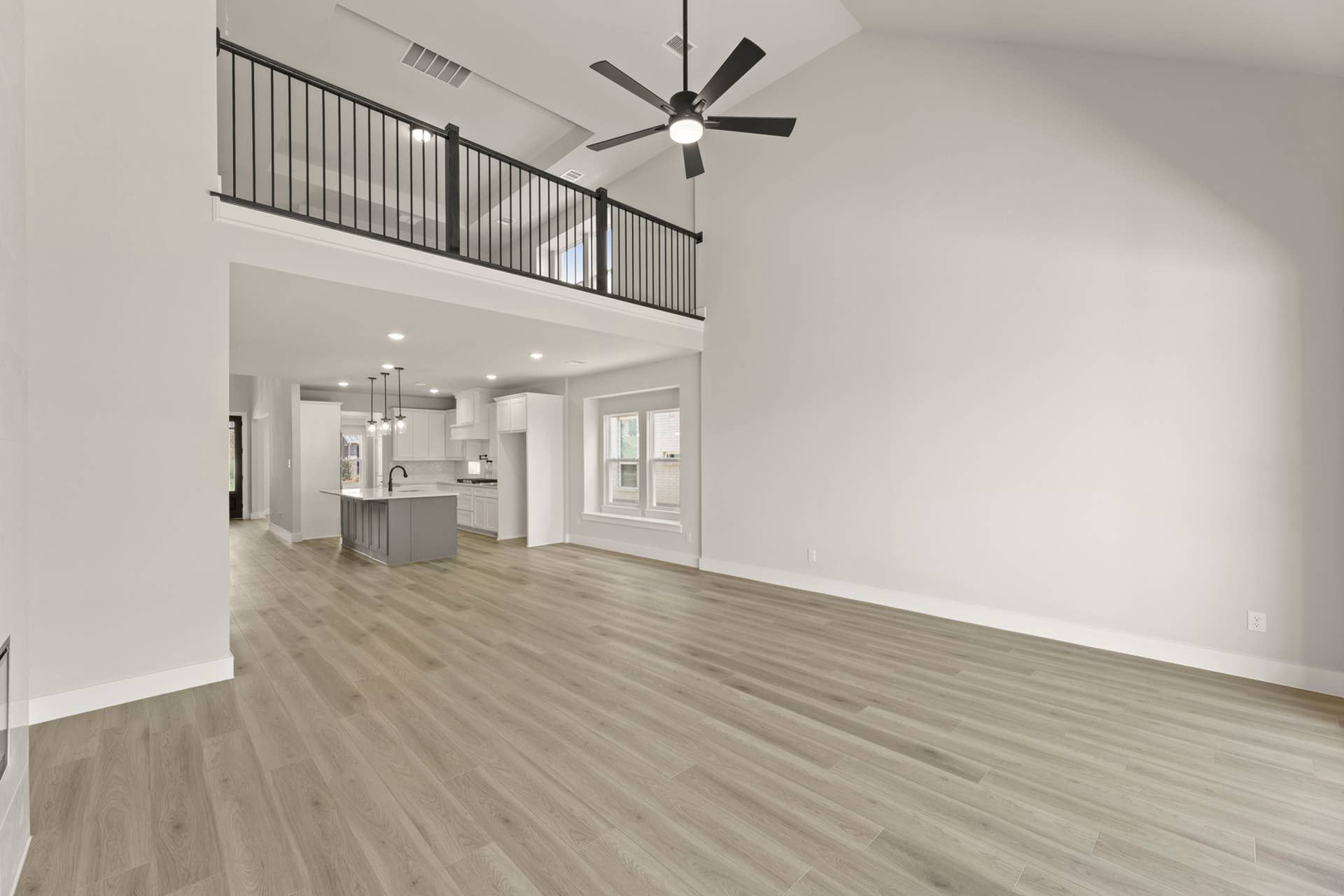 Spacious open-concept living area with high ceilings and modern kitchen.
