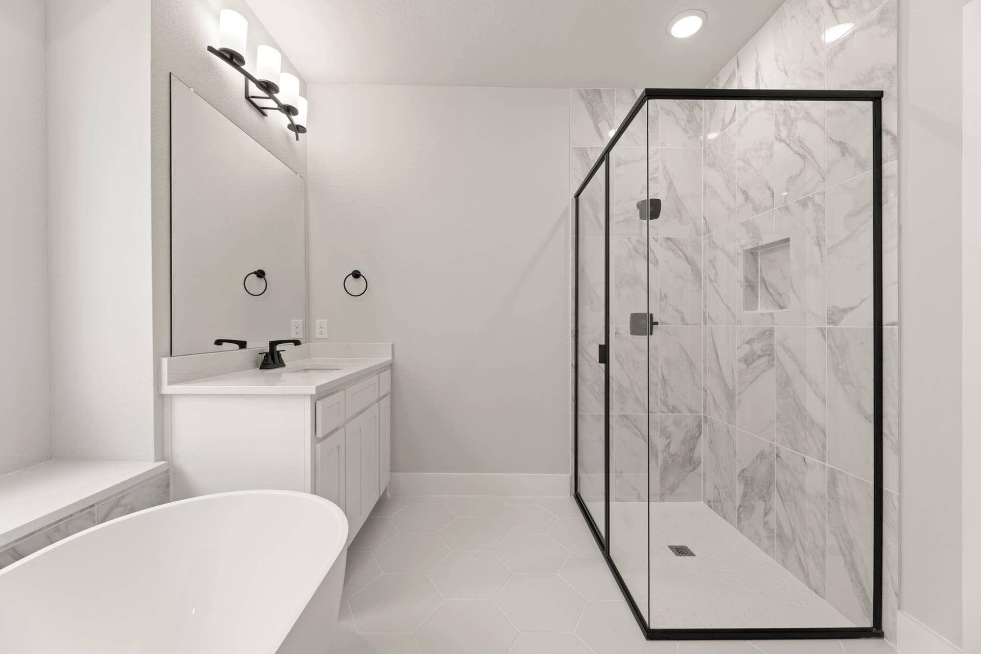 Modern bathroom with glass shower, freestanding tub, and sleek vanity.