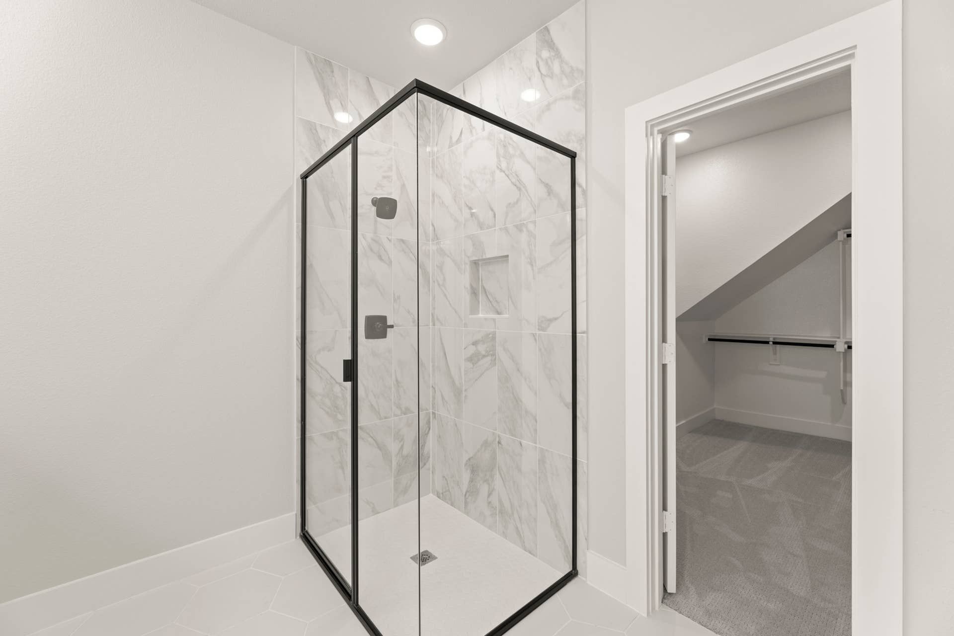 Modern bathroom with glass-enclosed shower and marble tile design.