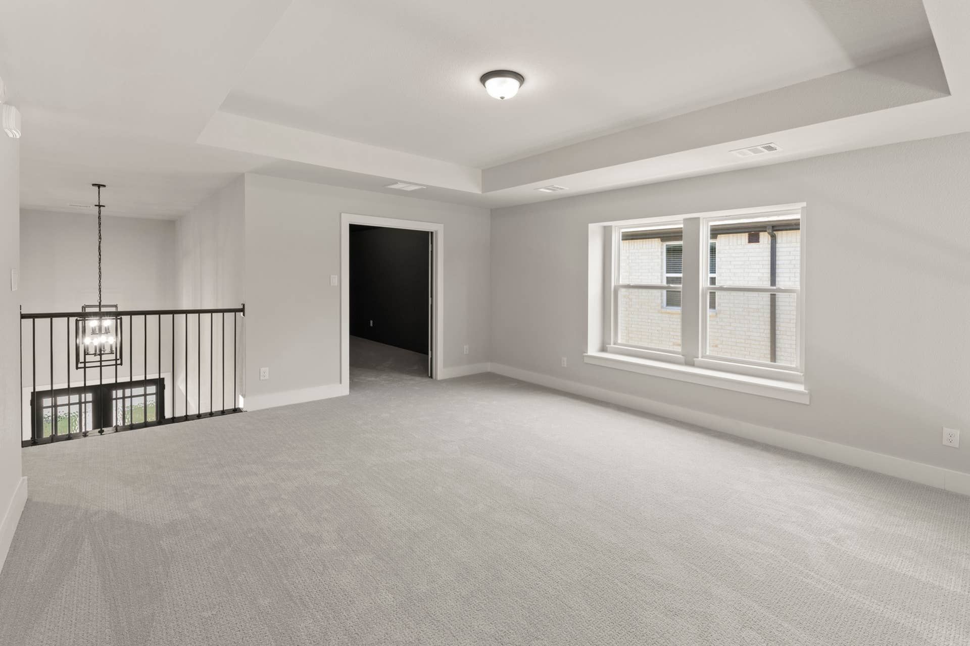 Spacious interior room with carpet flooring and large window.