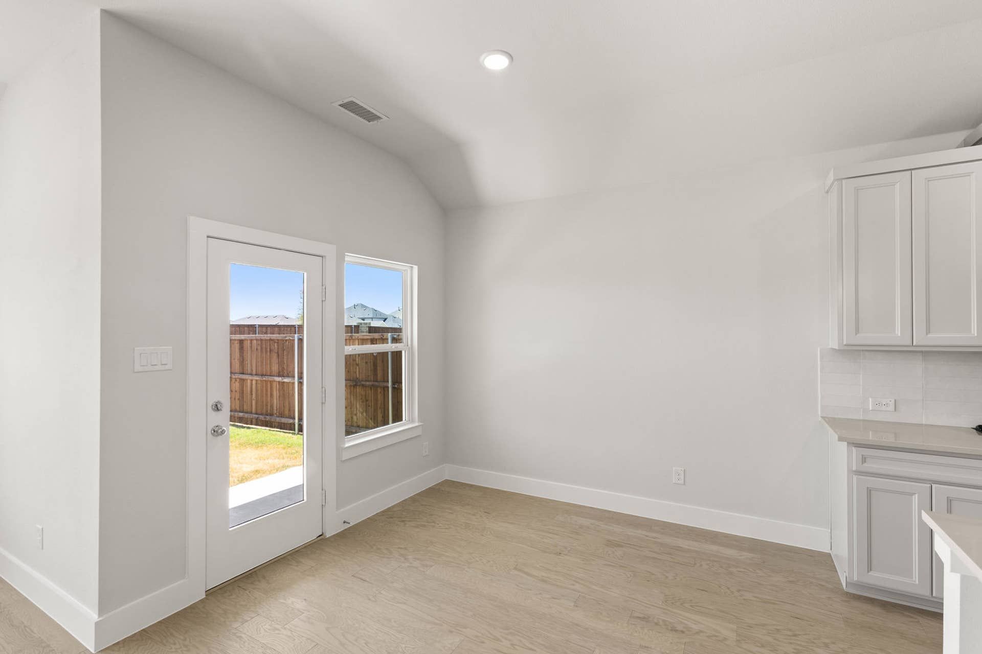 Bright dining area with patio door and wooden floors.