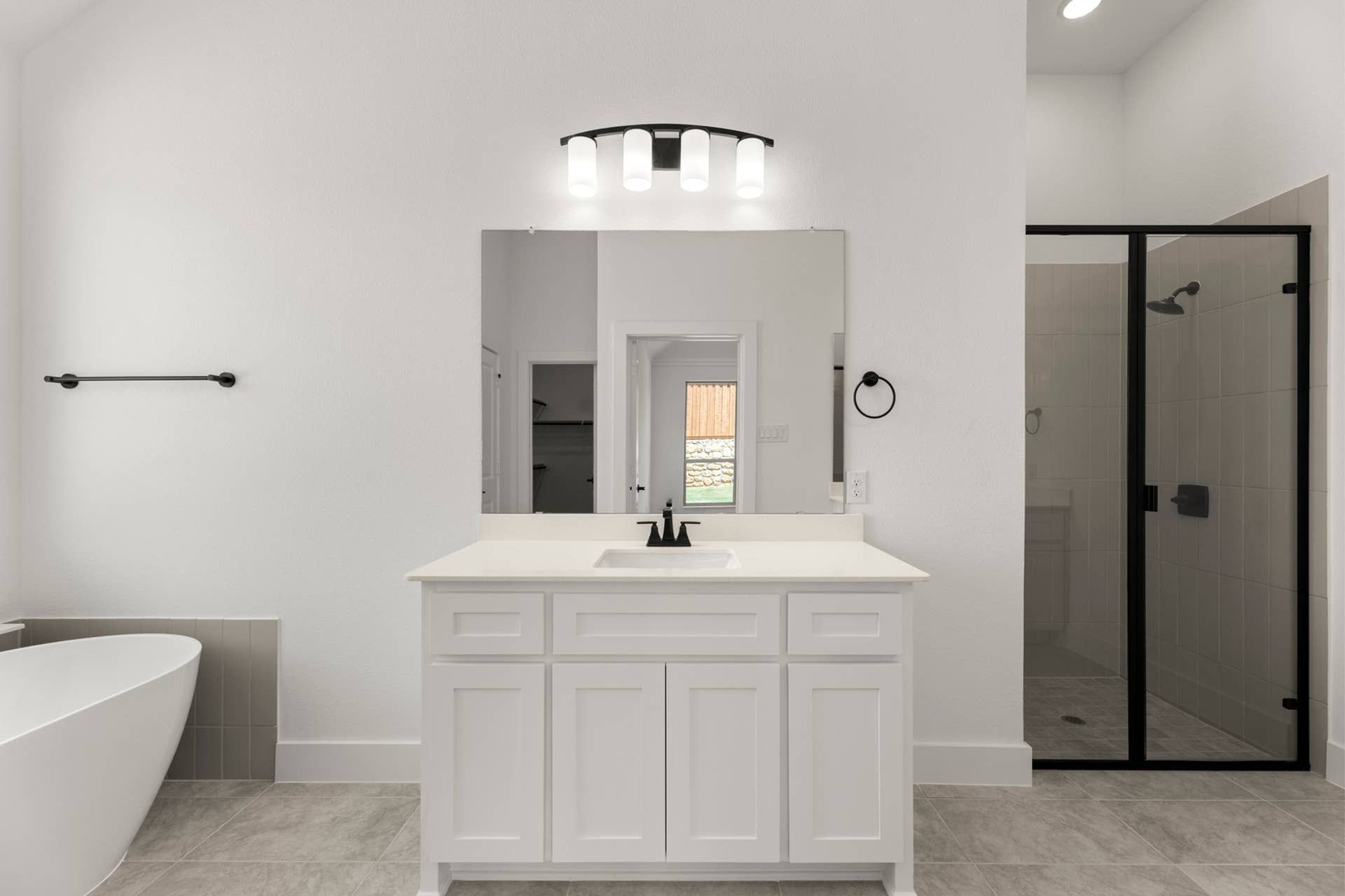 Modern bathroom with freestanding tub, glass shower, and white vanity.