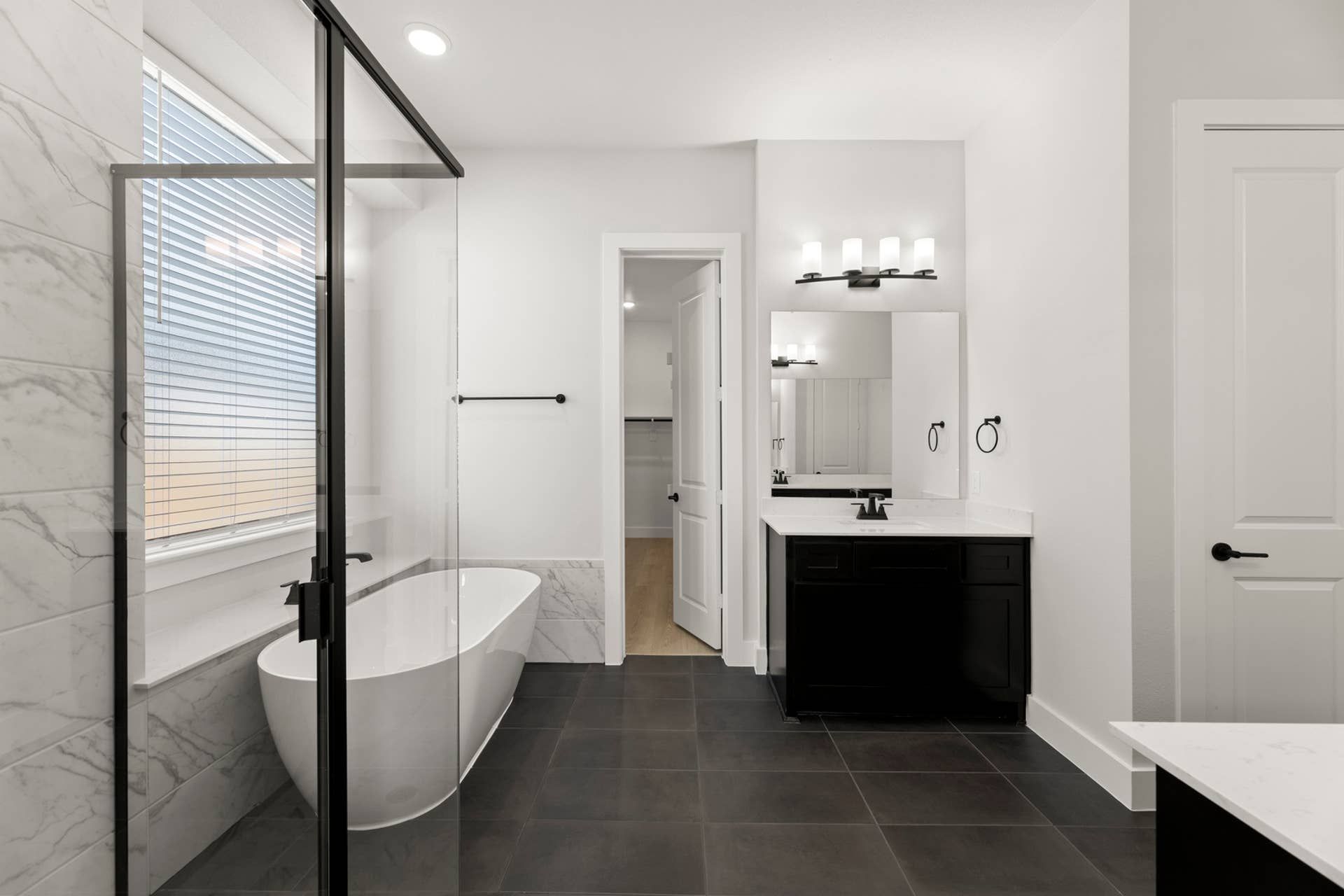 Modern bathroom with freestanding tub, glass shower, and sleek vanity.