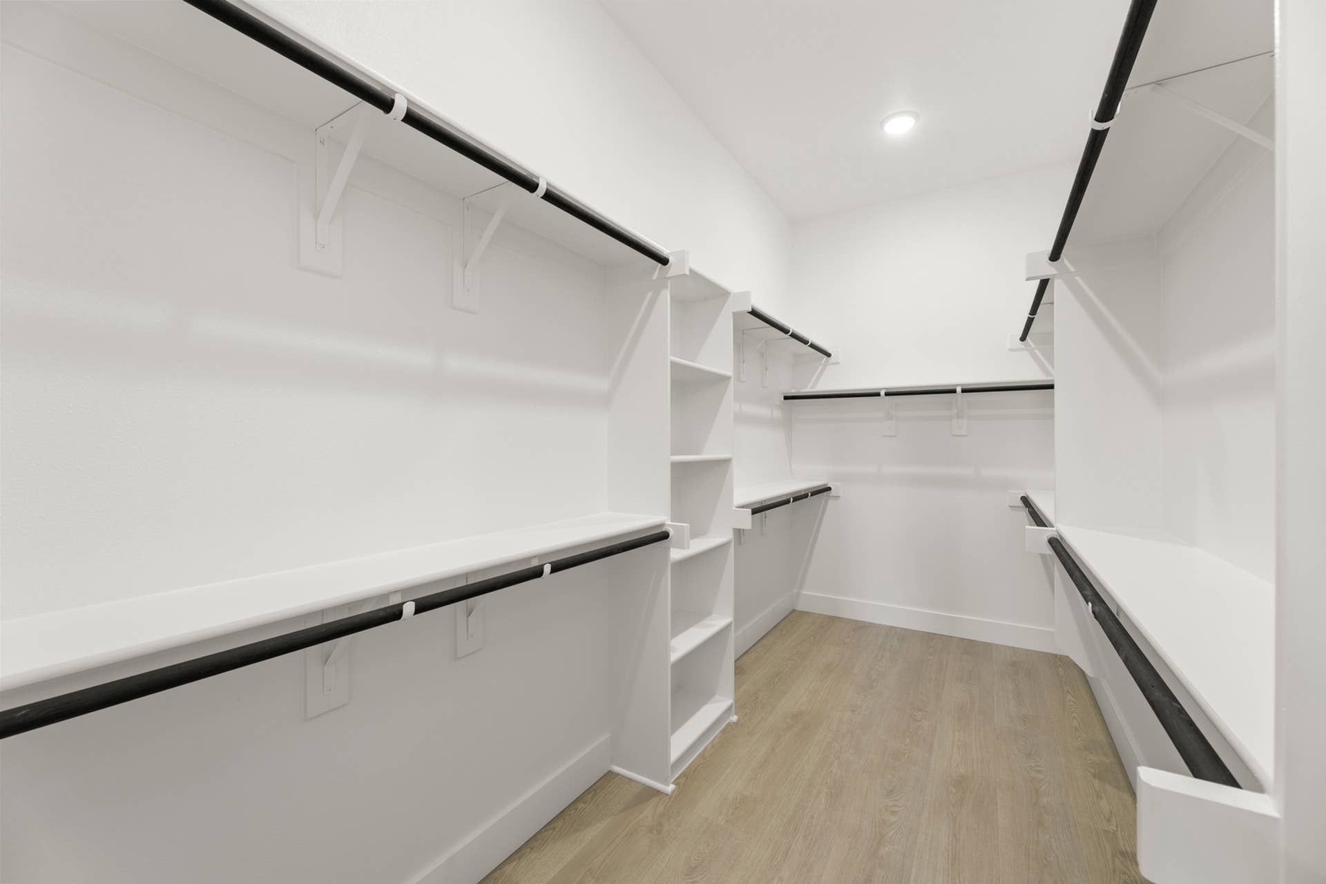 Spacious walk-in closet with shelving and hanging rods.