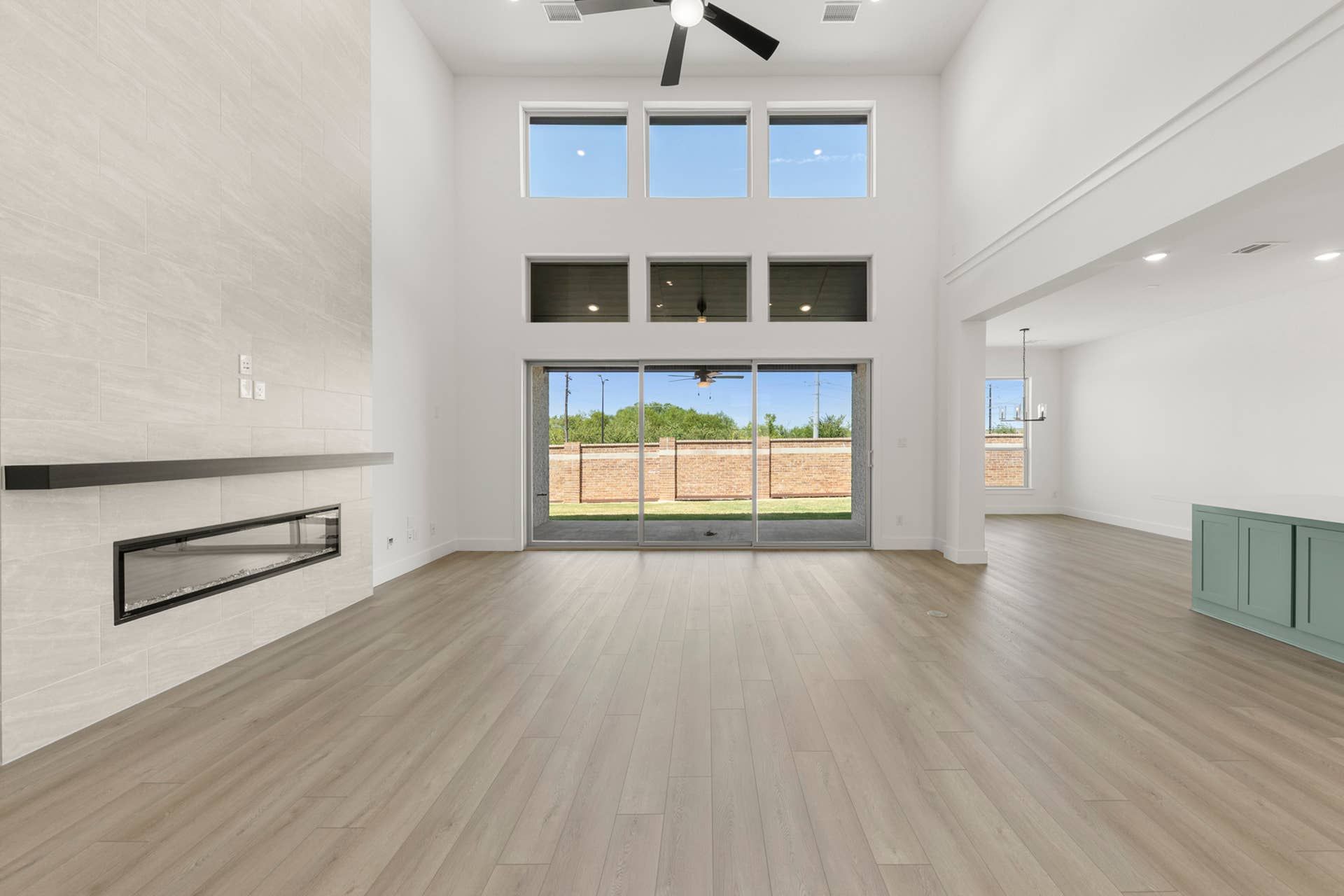 Spacious living area with high ceilings, modern fireplace, and large windows.