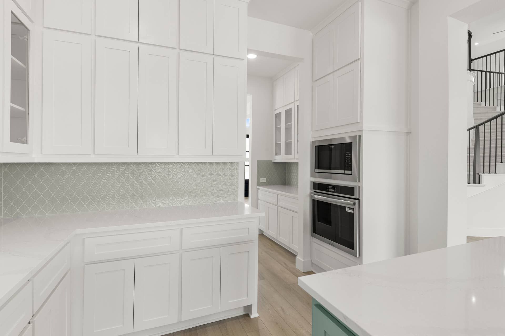 Modern kitchen with white cabinetry and stainless steel appliances.