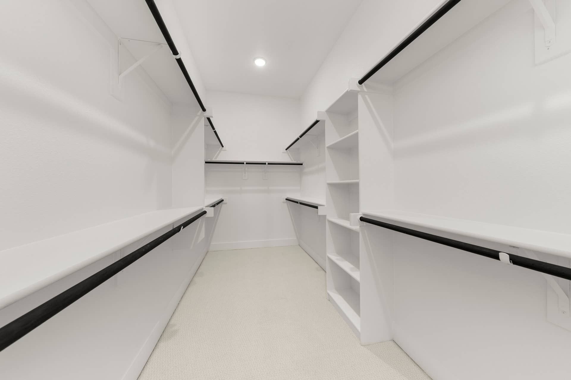 Spacious walk-in closet with ample shelving and hanging space.
