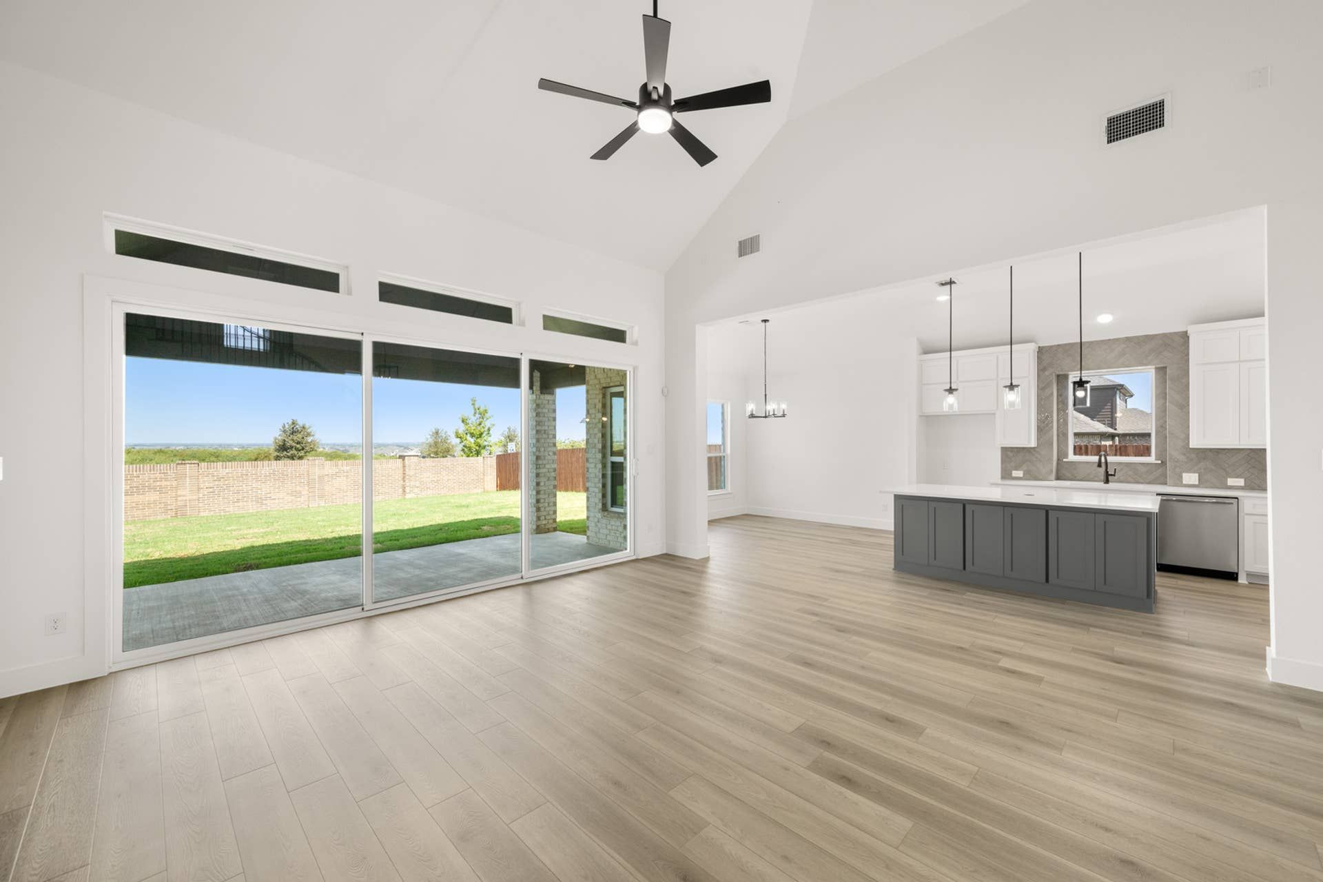 Spacious open-concept living room with large windows and modern kitchen island.